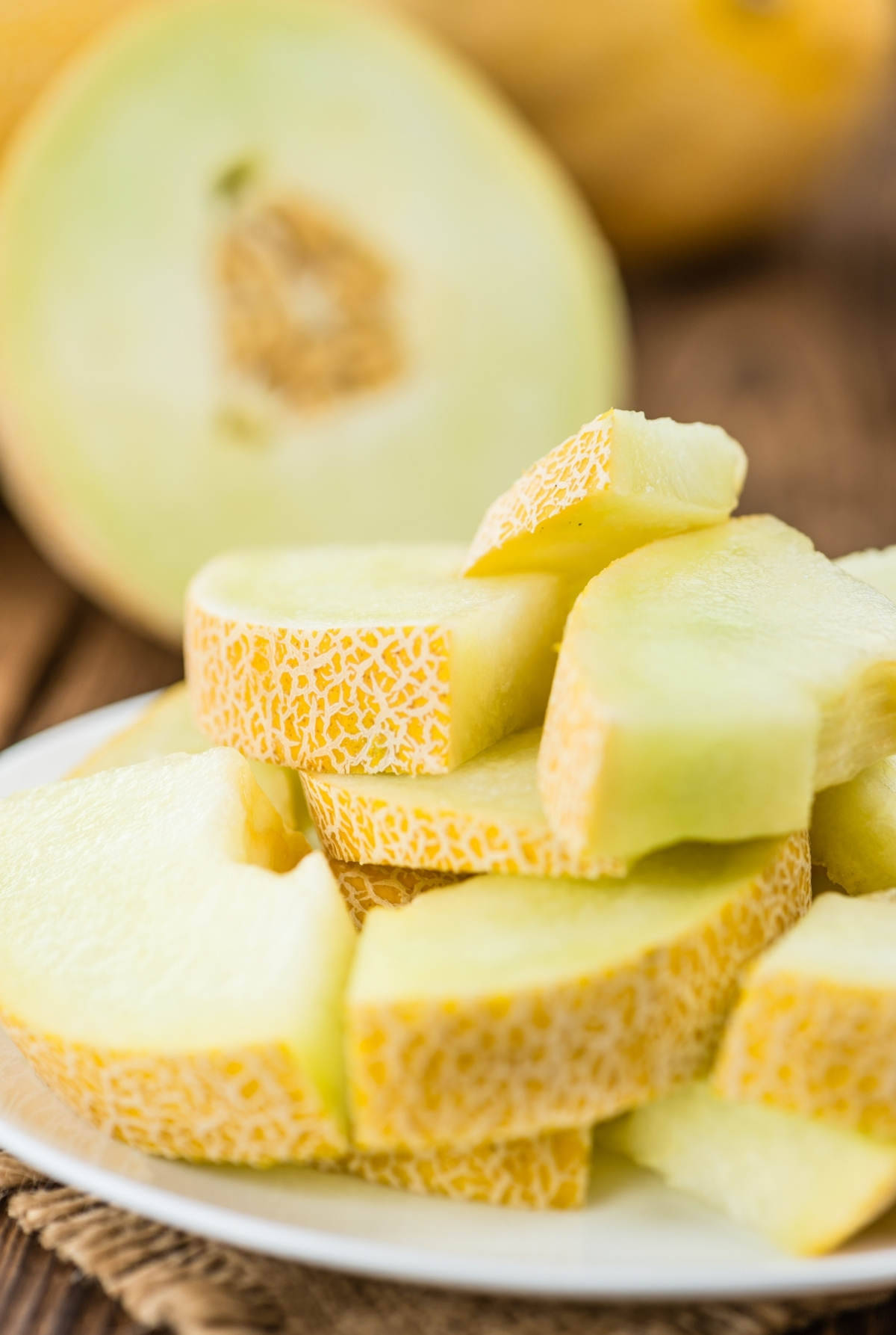 Sliced Brown Honeydew Melon On A Plate Background