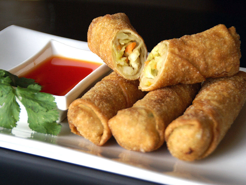 Sliced Egg Rolls With Sweet Sauce Dip Background