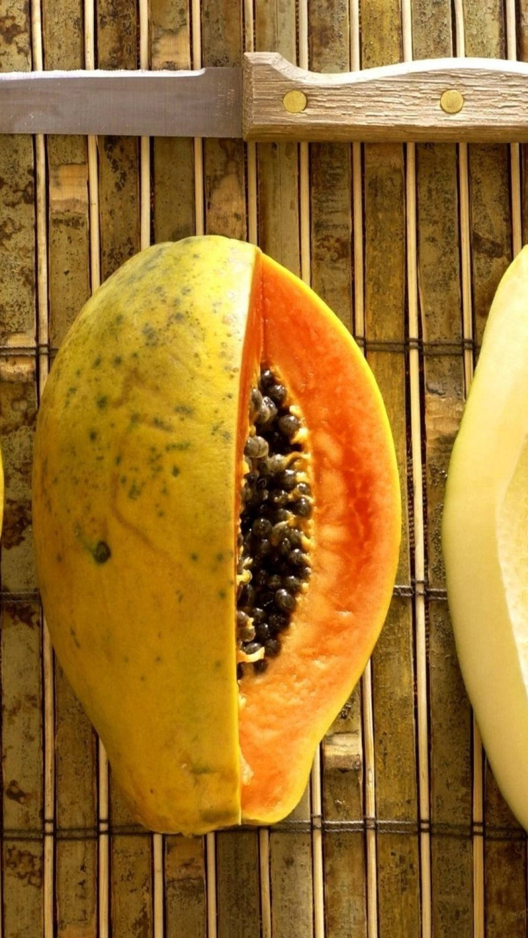 Sliced Fresh Papaya Fruit On Bamboo Mat Background