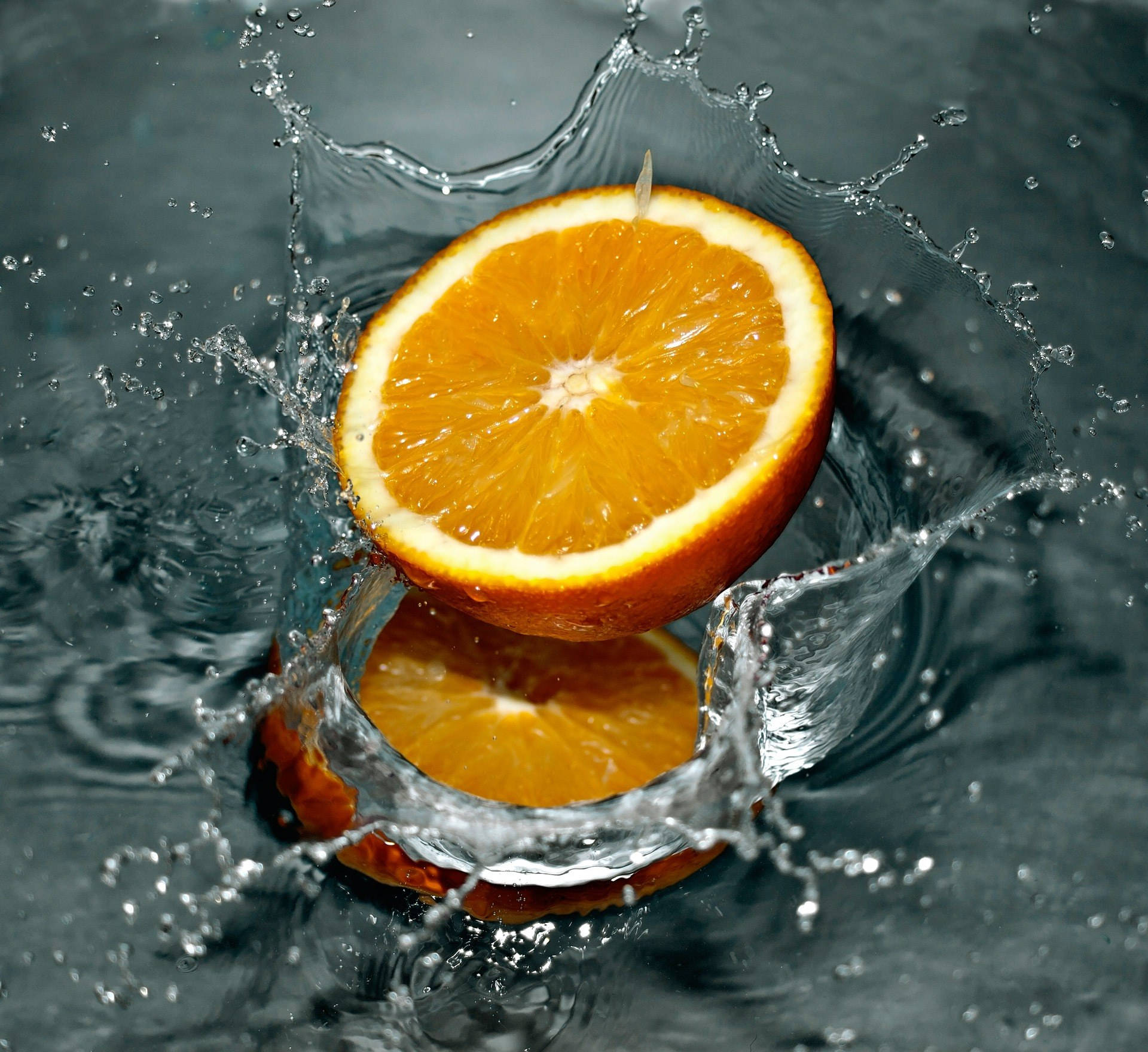 Sliced Orange Falling In The Water