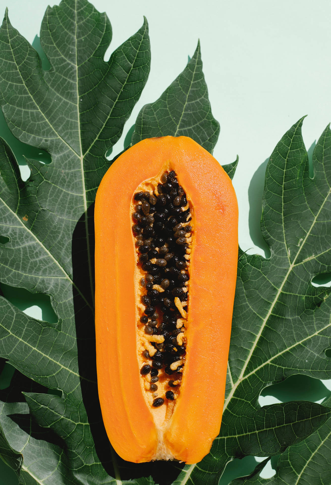 Sliced Papaya Fruit And Leaf Background