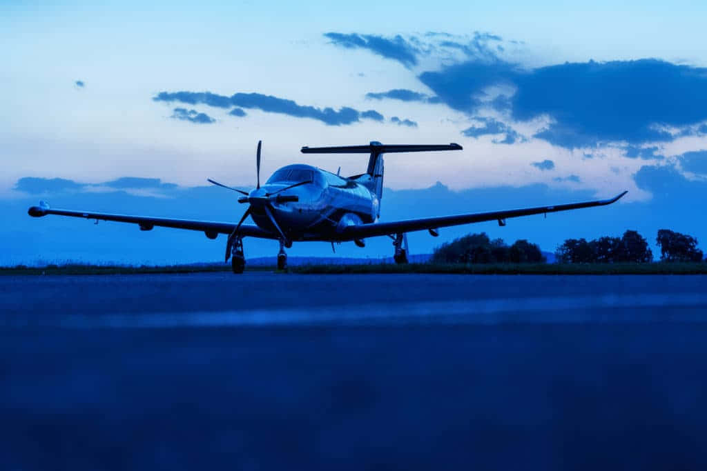 Small Airplane On Runway At Dim Afternoon Background