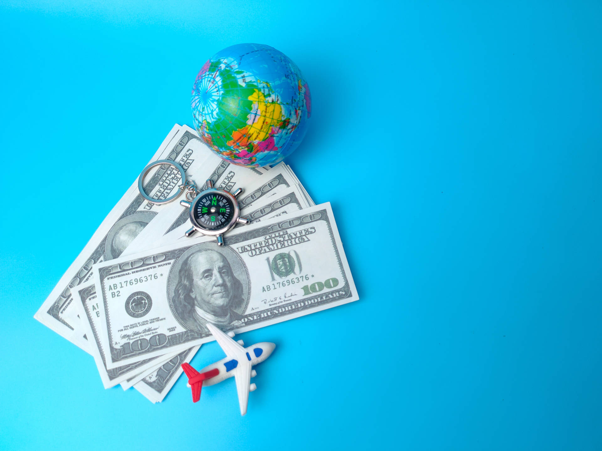 Small Plane Beside Dollar Bills & Globe Background