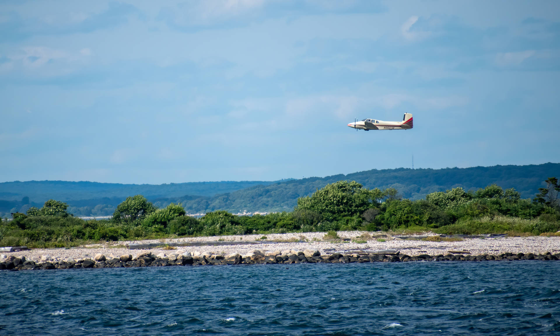 Small Plane Flying Over Ocean Background