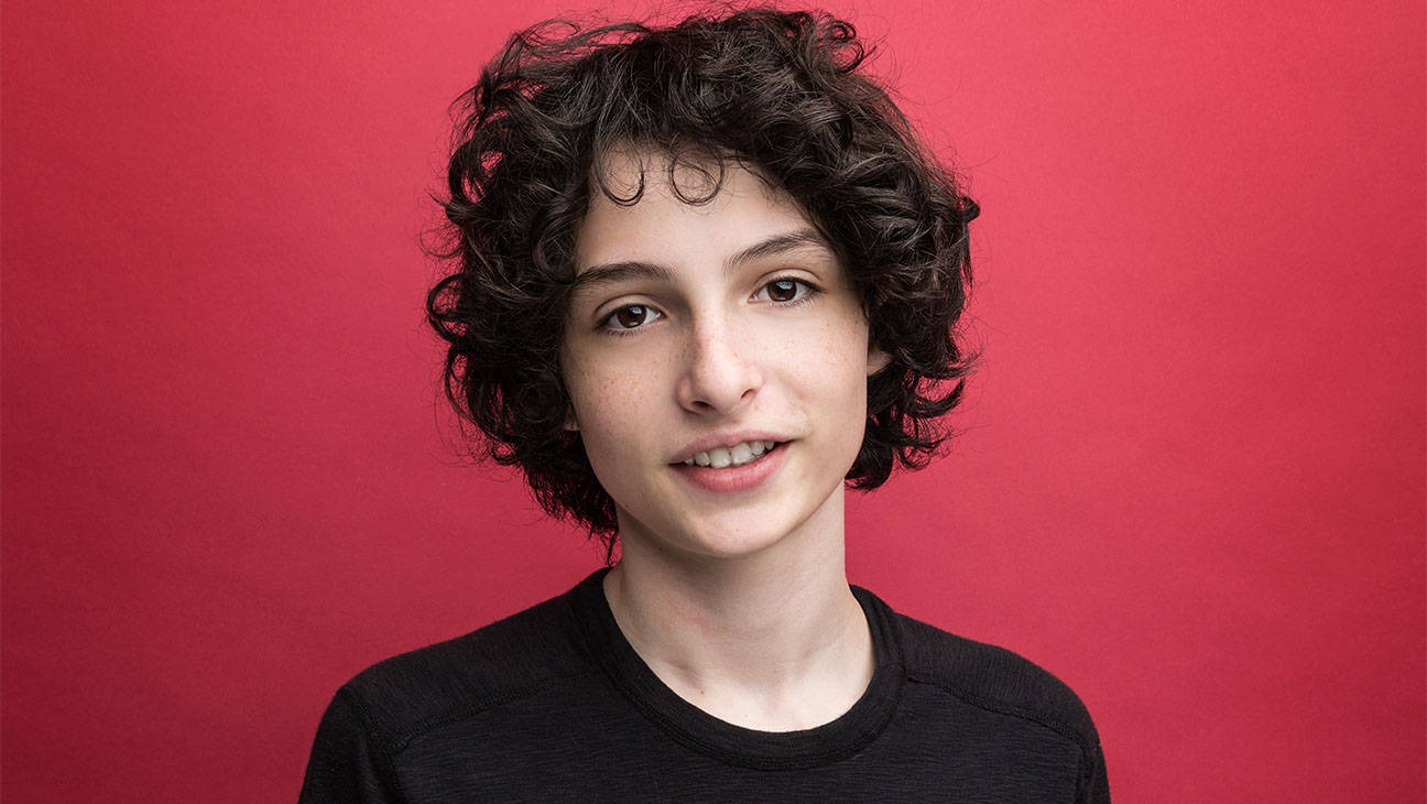 Smiling Curly-haired Finn Wolfhard Background