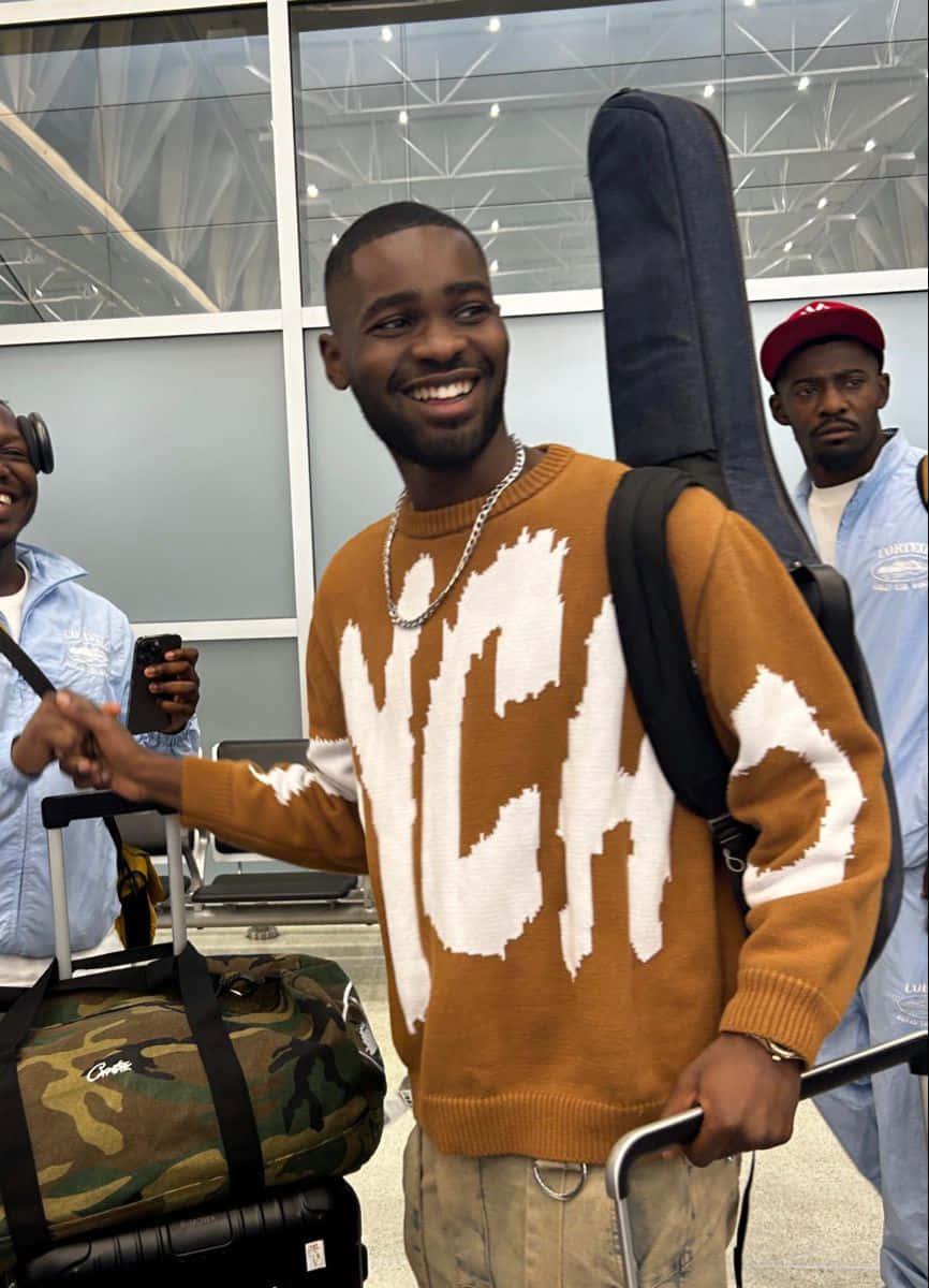 Smiling Man With Guitar Case At Airport Background