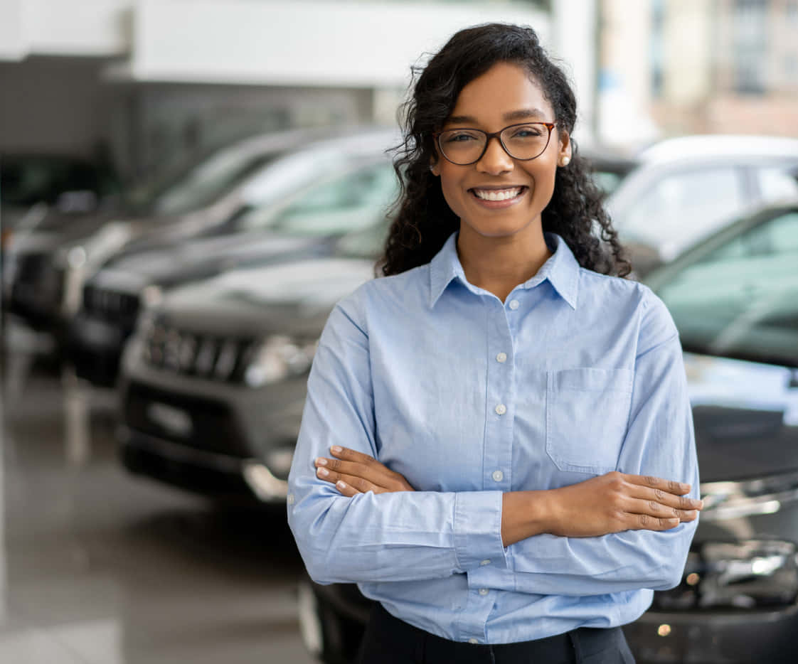 Smiling Young Black Woman At Car Dealership Background