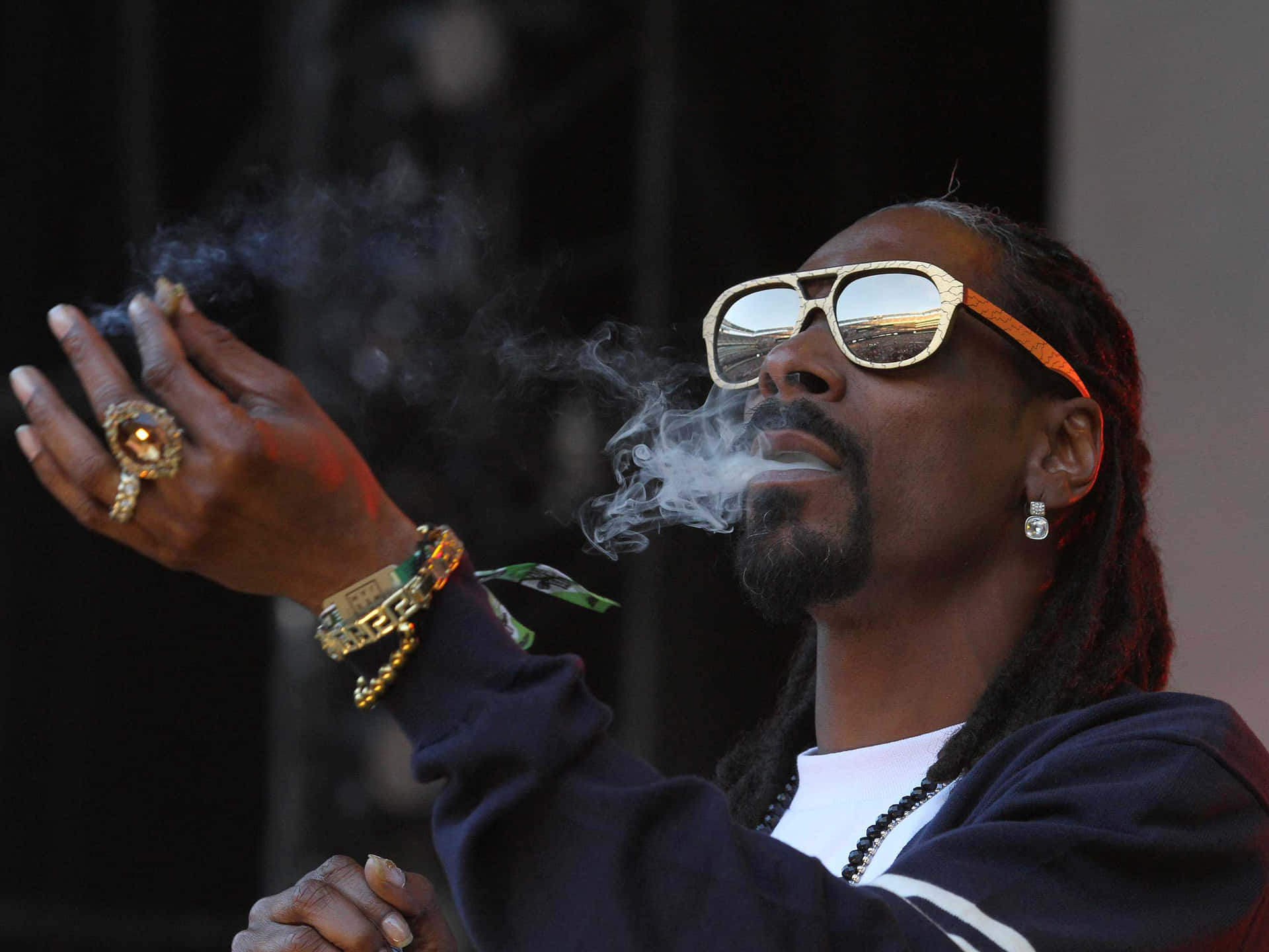 Snoop Dogg Smokes A Cigarette At A Concert Background