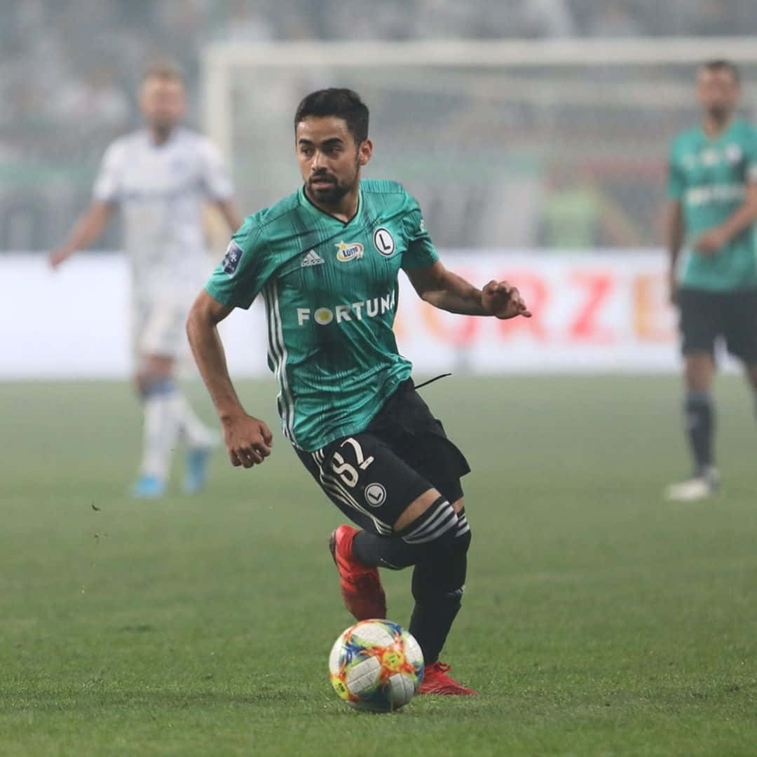 Soccer Player Controling Ball During Match Background