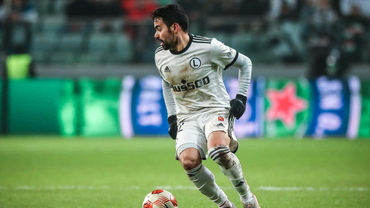 Soccer Player Controling Ball During Match Background