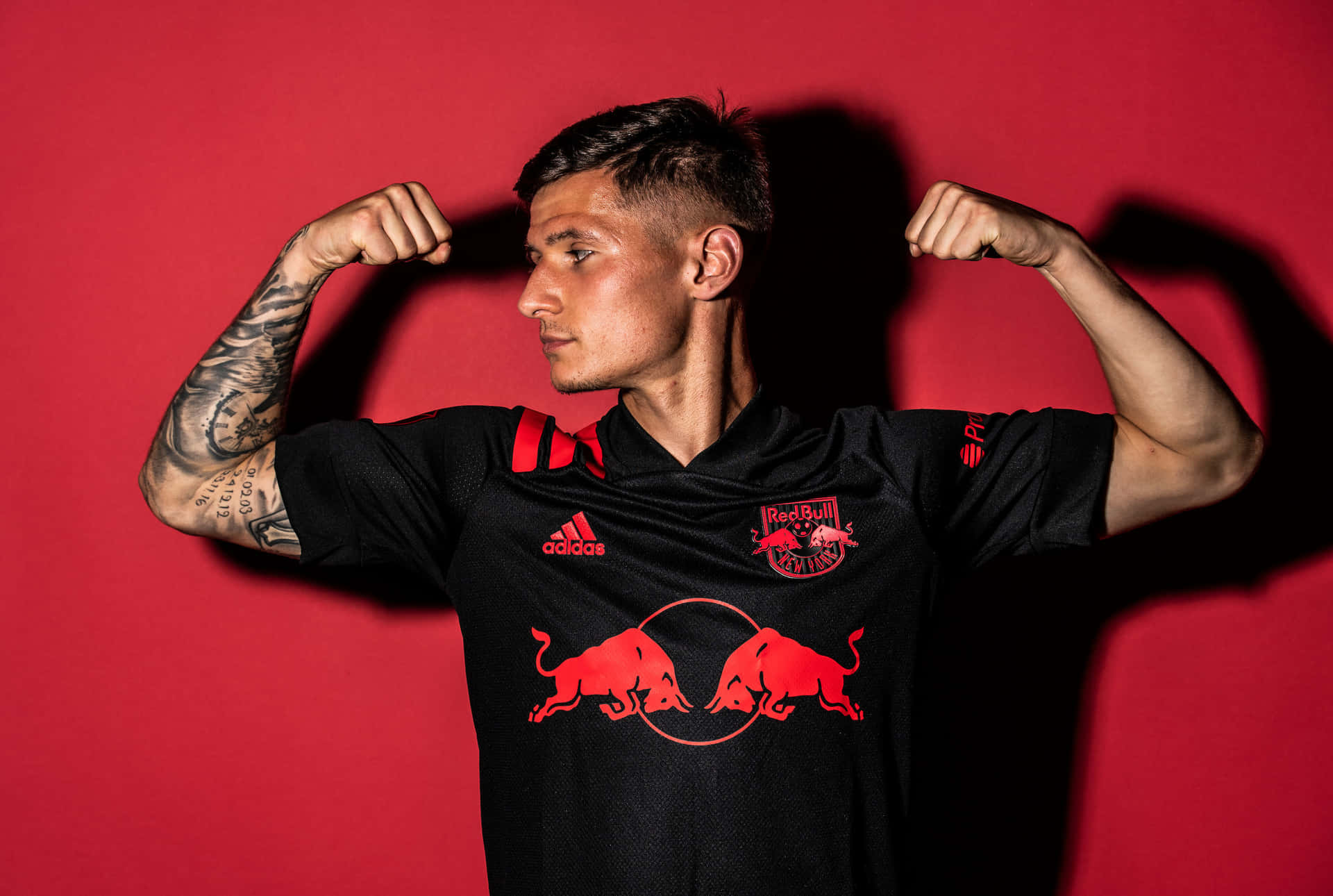 Soccer Player Flexingin Red Bull Jersey Background