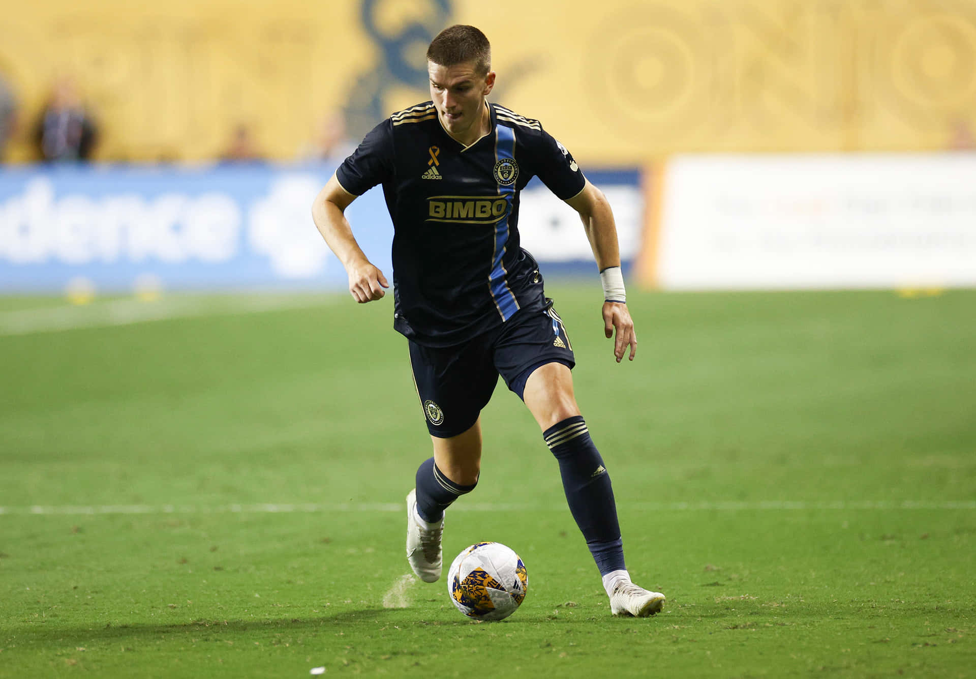 Soccer_ Player_in_ Action_on_ Field Background