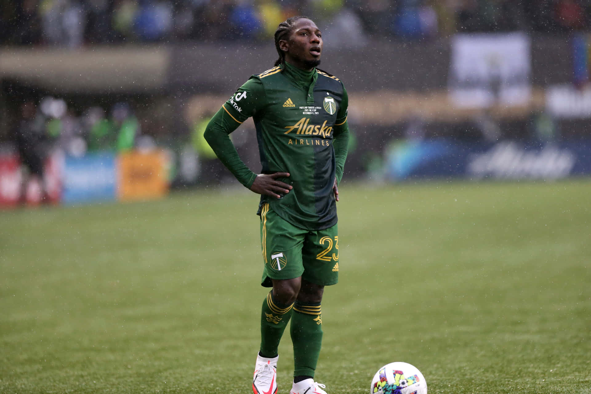 Soccer_ Player_in_ Green_ Kit_ Rainy_ Game_ Day Background