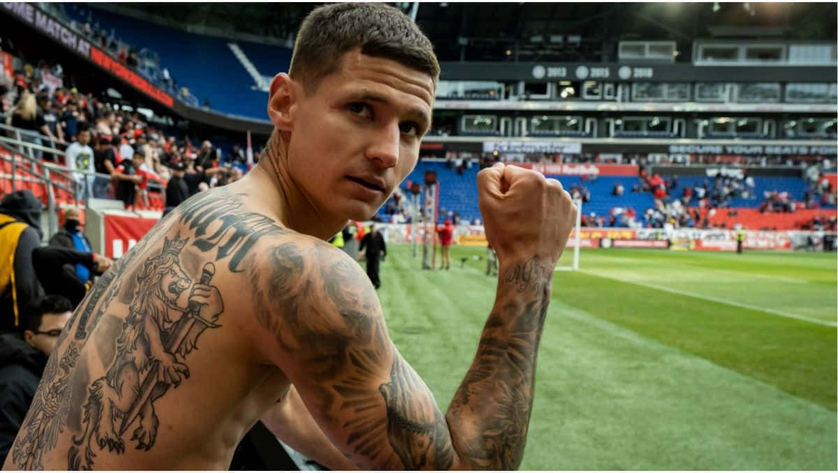 Soccer Player Showing Tattoos Stadium Background Background