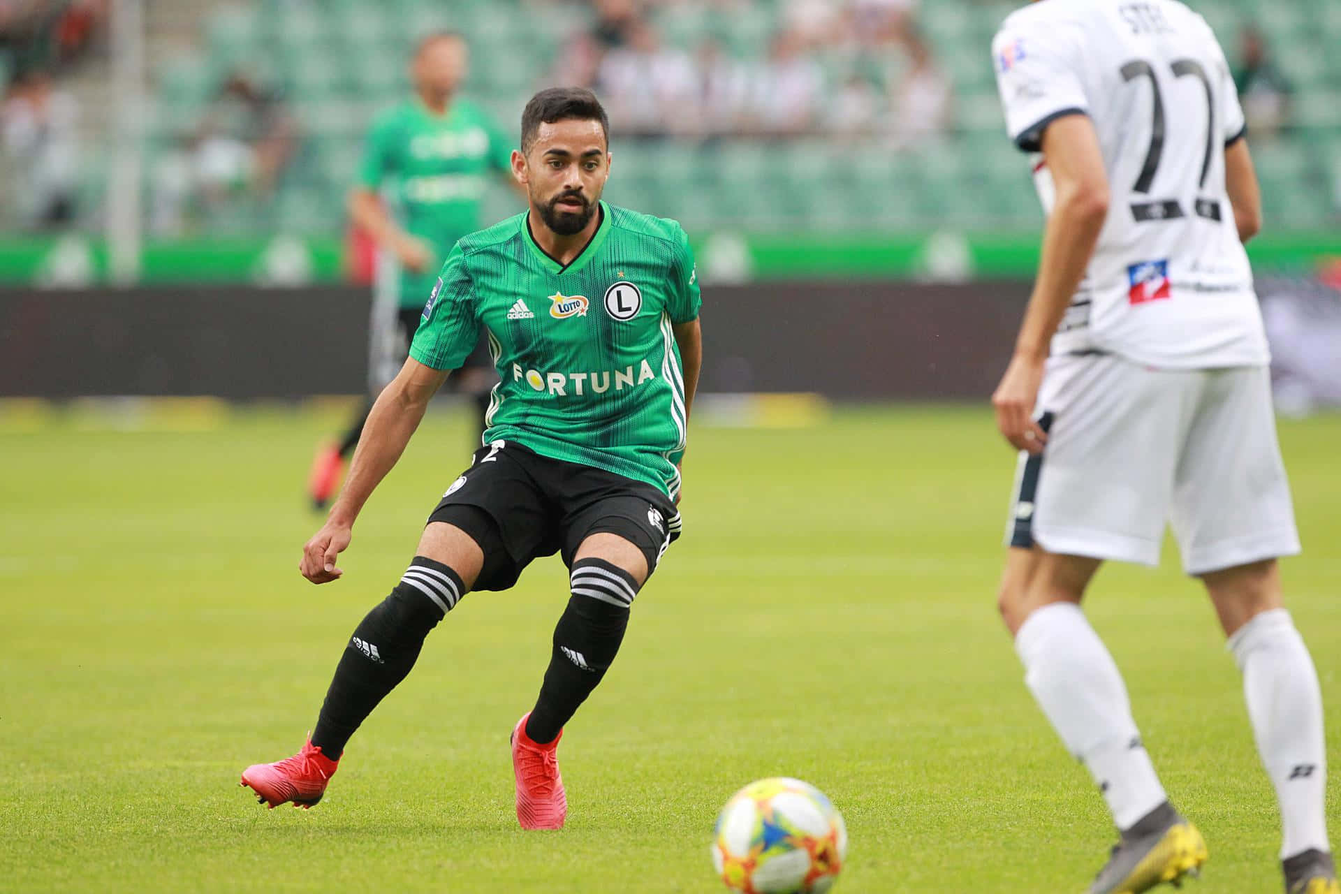 Soccer Playerin Green Dribbling Ball Background