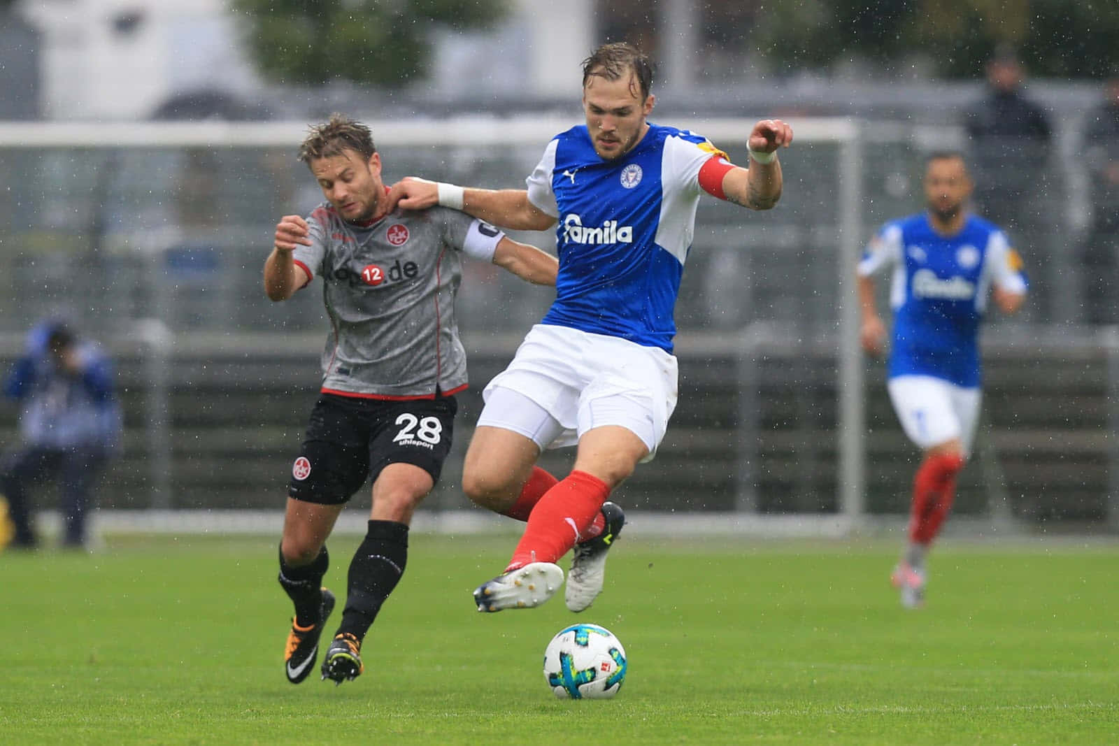 Soccer Players Competingin Rainy Match Background