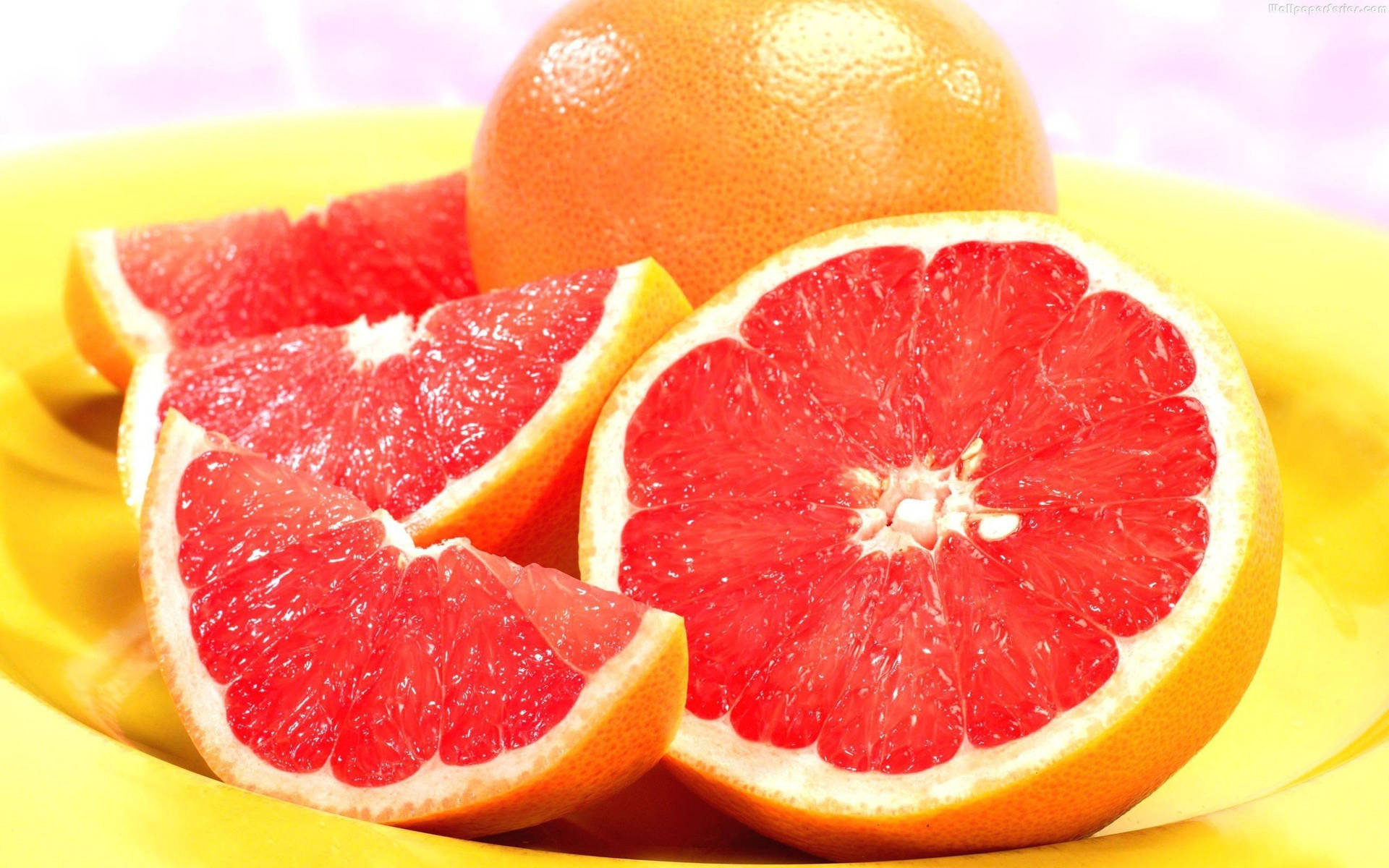 Soft Pink Grapefruits On A Plate Background