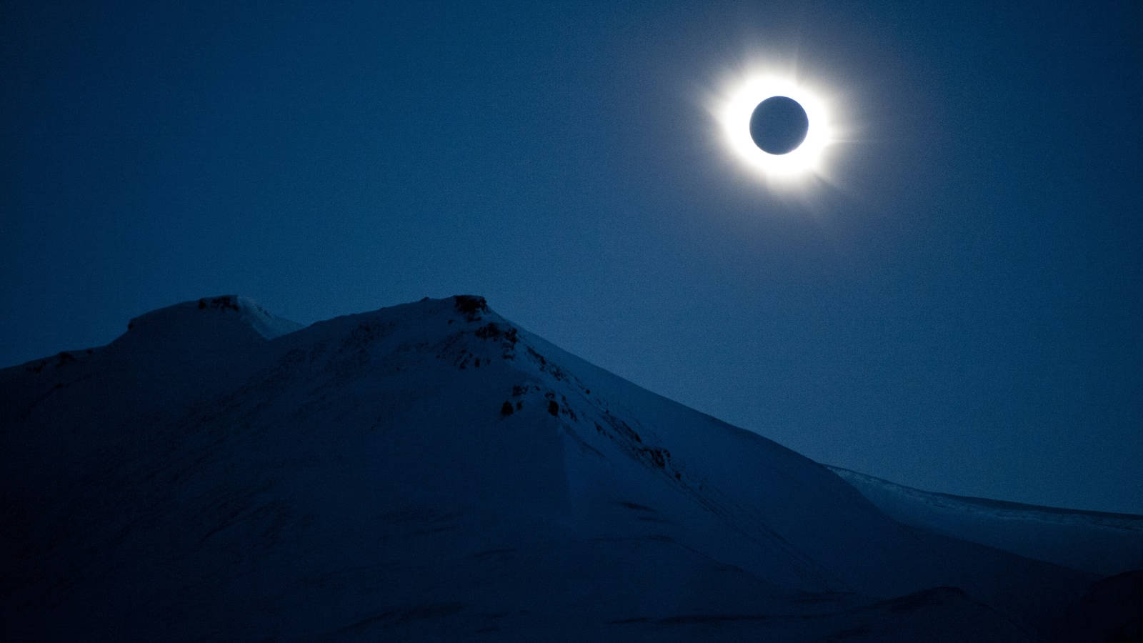 Solar Eclipse Over Snow-capped Mountain Background