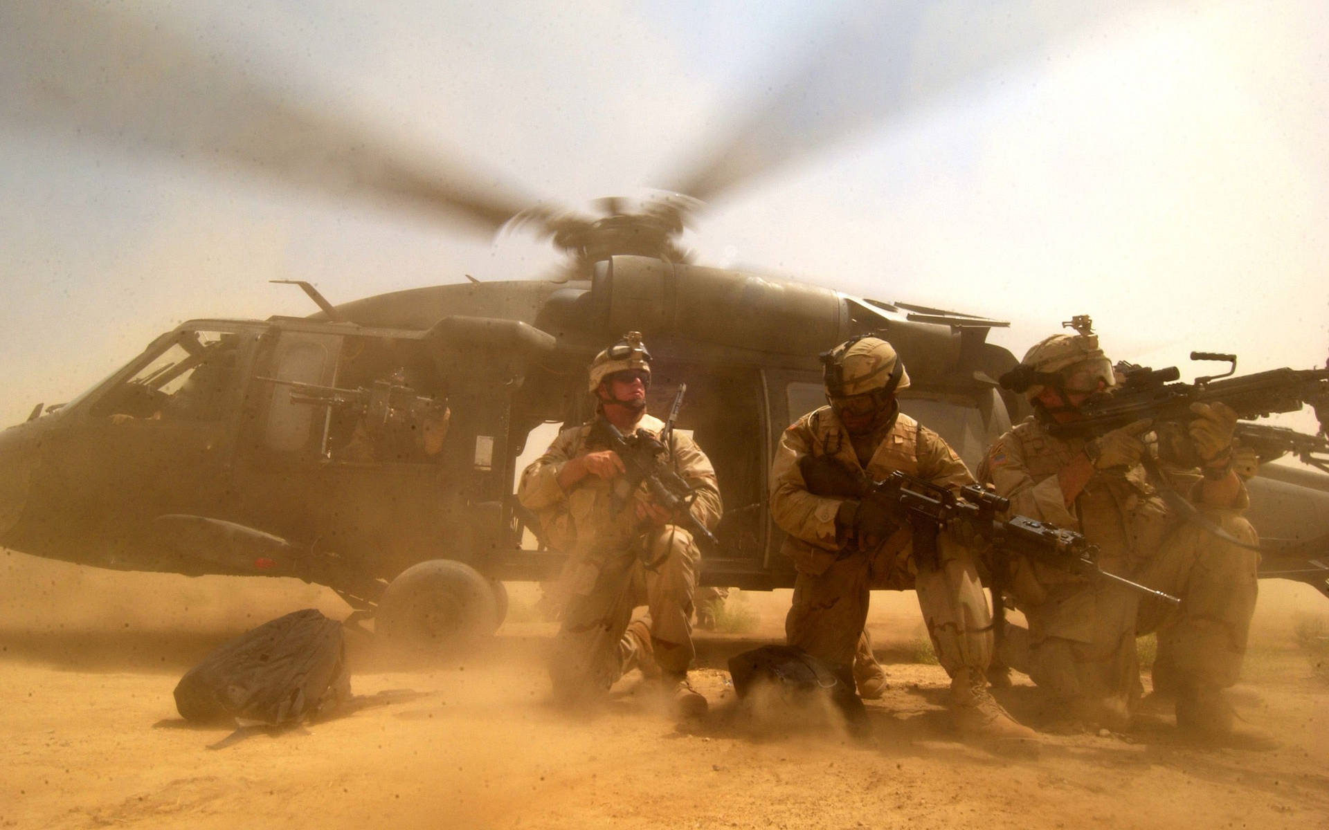 Soldiers On Ground With Black Hawk Helicopter Background