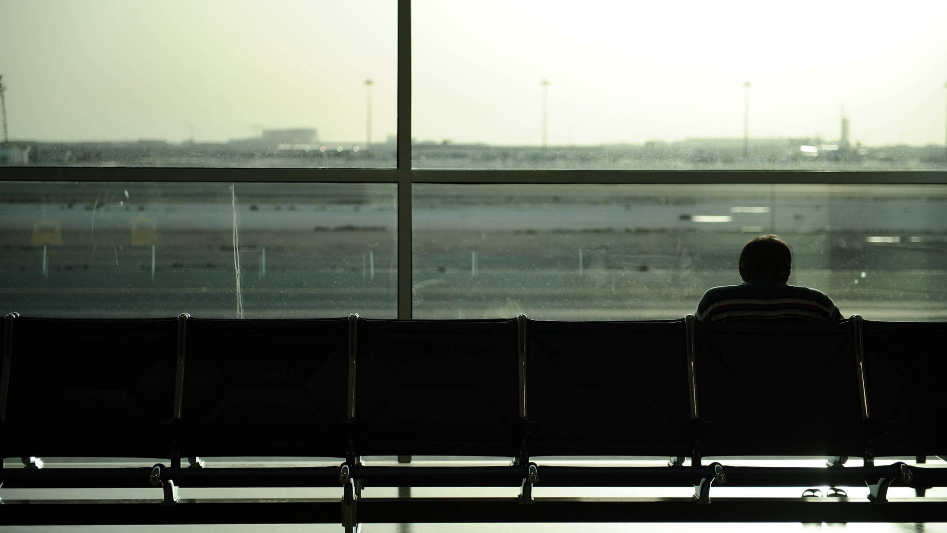 Solitary Man Waiting At Airport Lounge Background