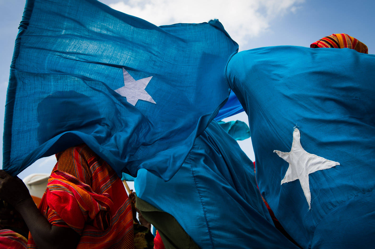 Somalia Flags In Crowd Background