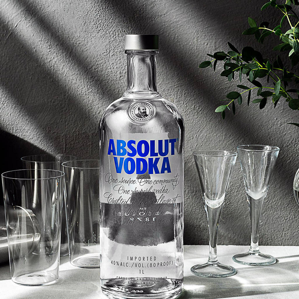 Sophisticated Absolut Vodka Bottle With Glasses In Black And White Background