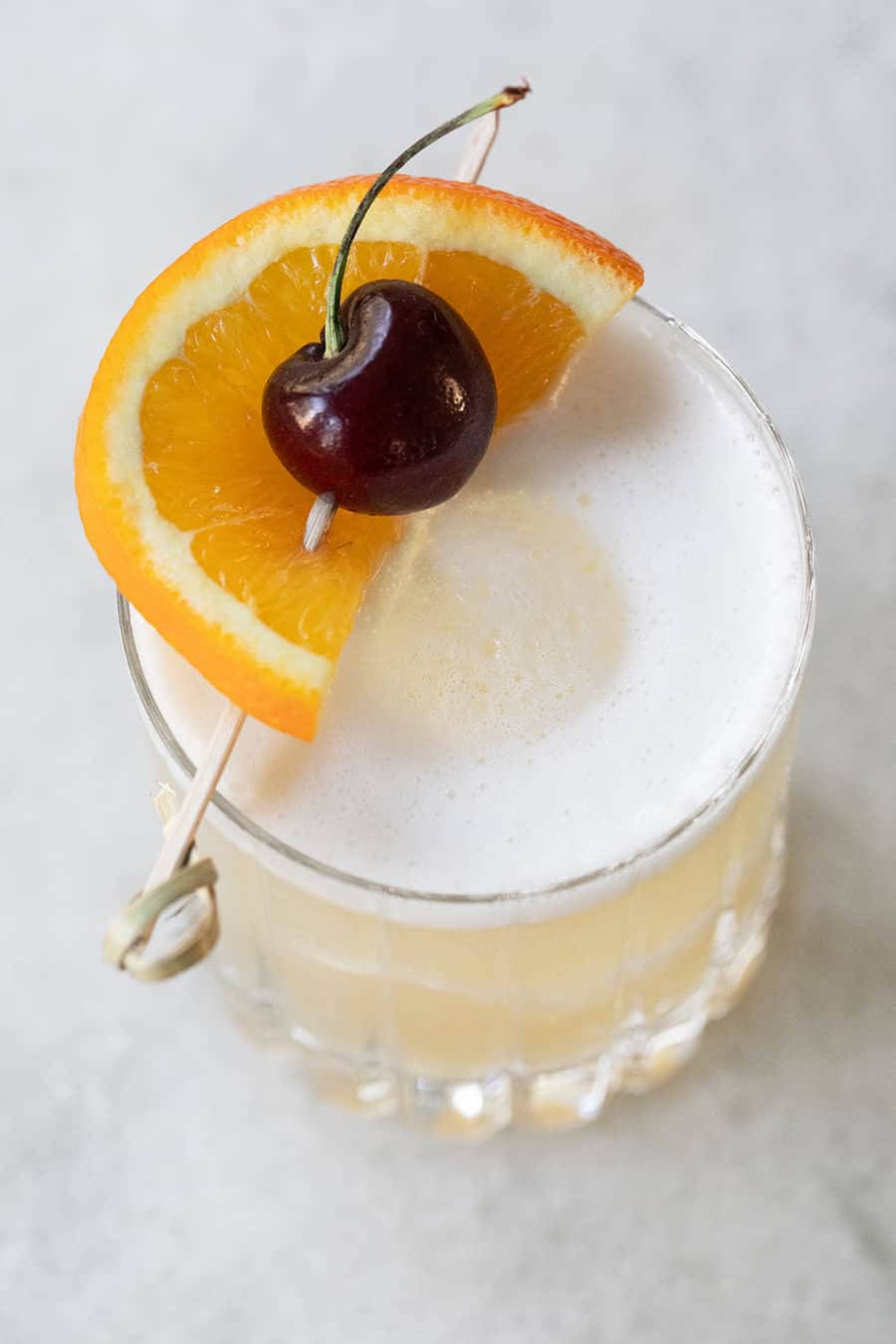 Sour Cocktail With Orange And Cherry Background