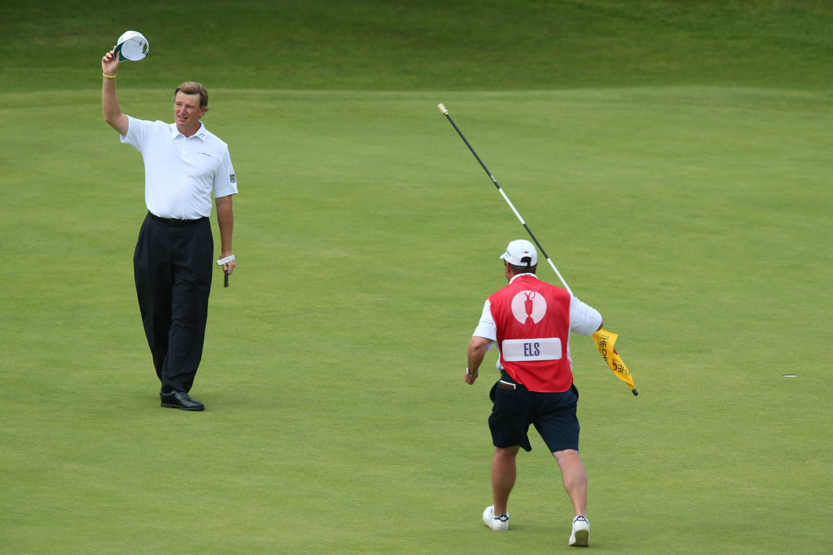 South African Pro Golfer Ernie Els With His Caddy On The Golf Course Background