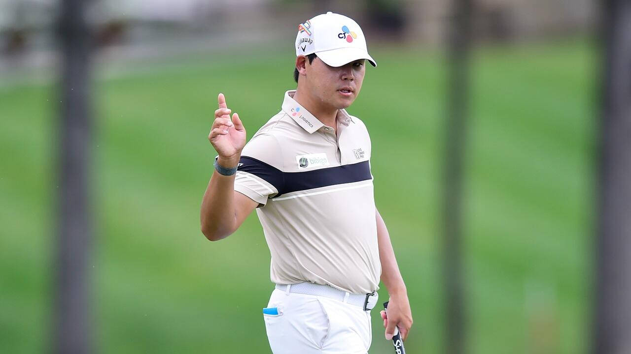 South Korean Professional Golfer Si Woo Kim Signaling On The Course Background