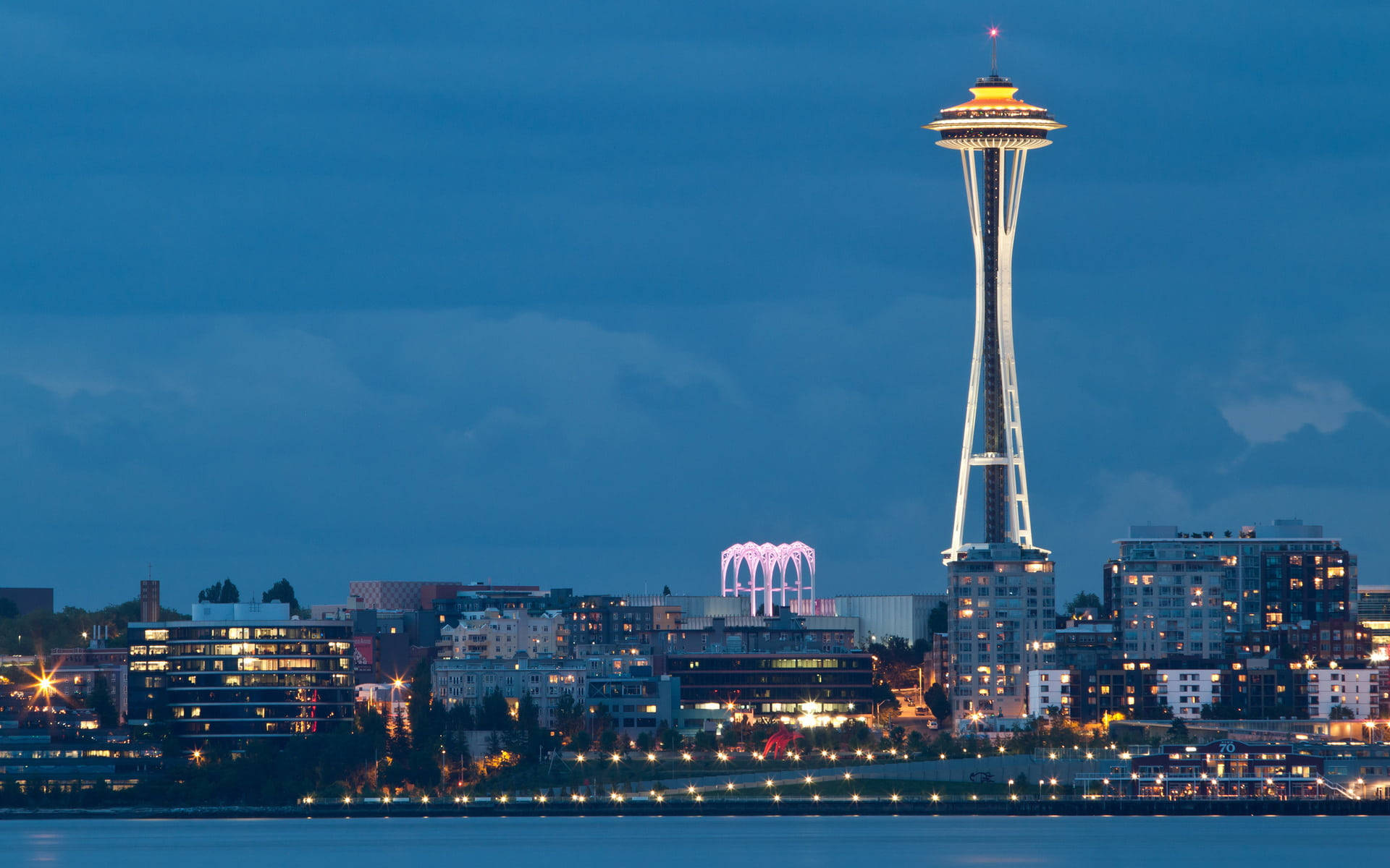 Space Needle Towering Over Buildings Background