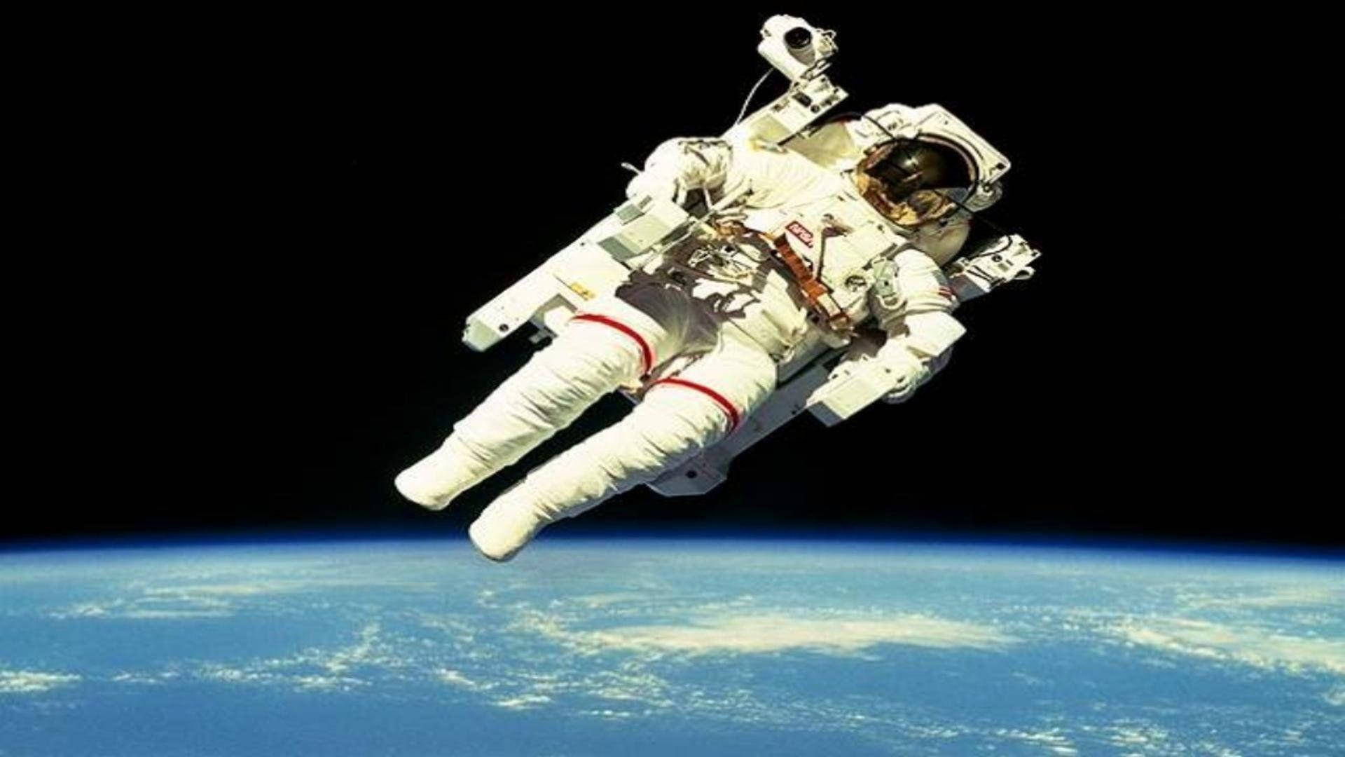 Spaceman Floating Above The Earth Background