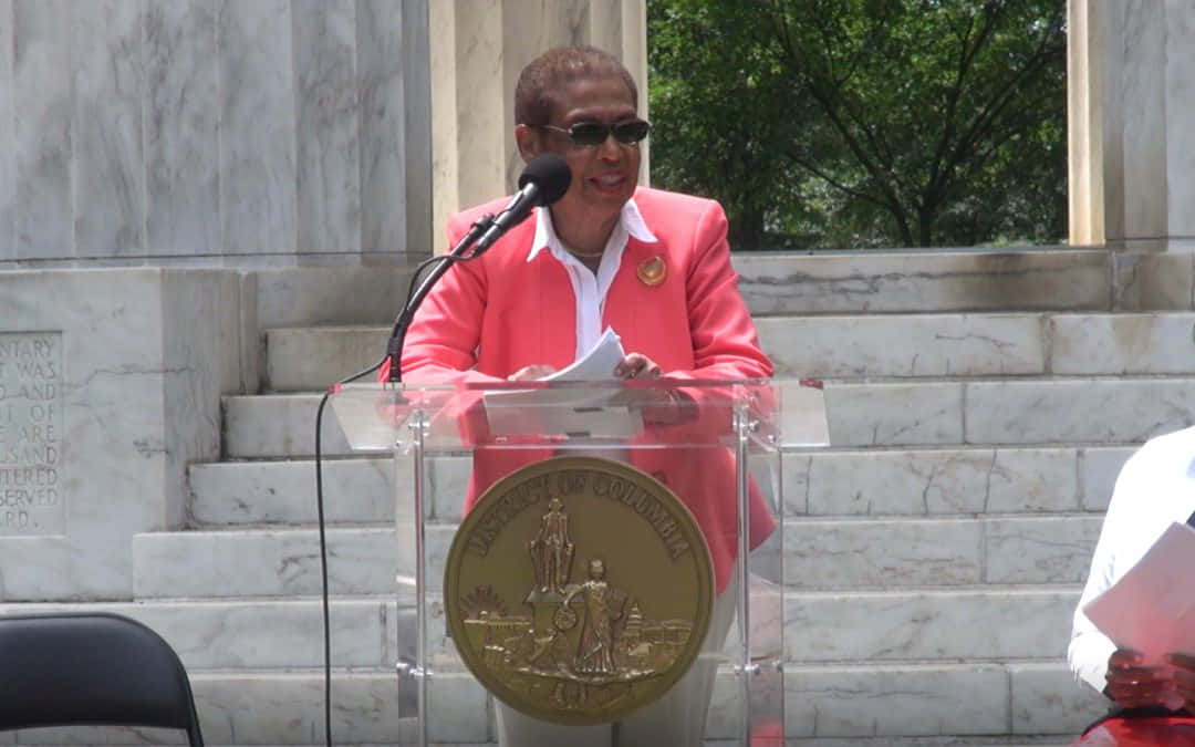 Speech Delivery Of Eleanor Holmes Norton On A Sunny Day Background