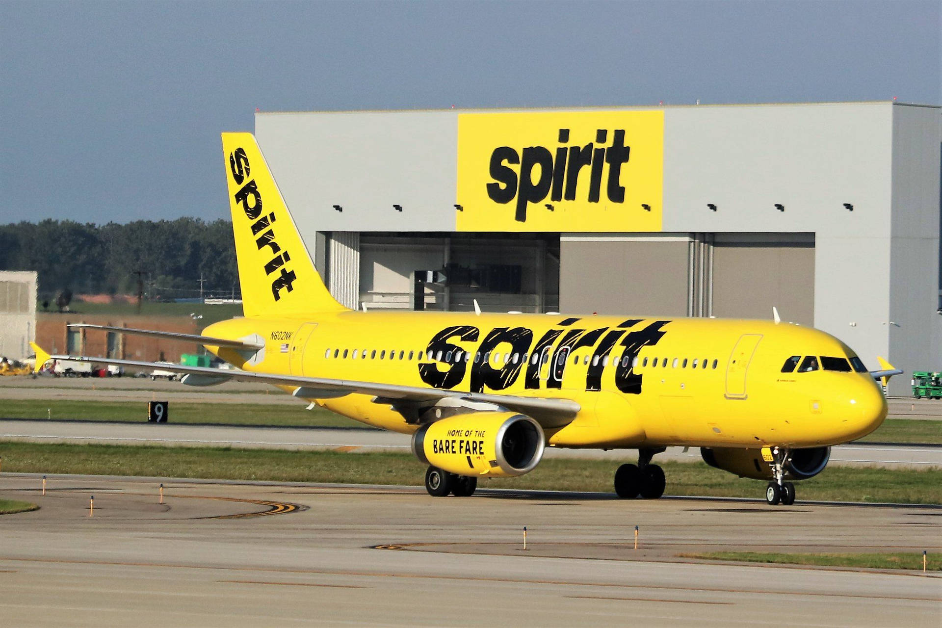 Spirit Airlines' Bright Yellow Airplane Preparing For Takeoff Background