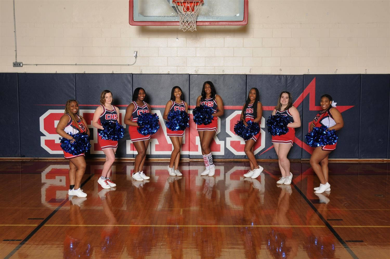 Spirited Cheerleaders Motivating On Court Background