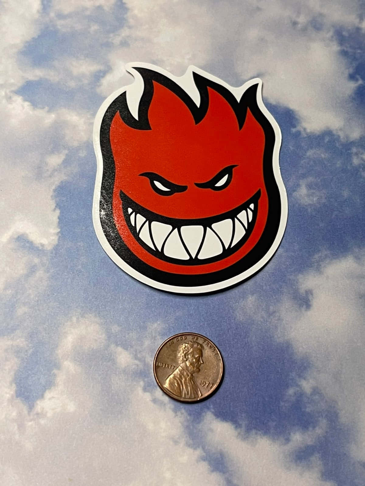 Spitfire Skate Sticker And A Coin Background