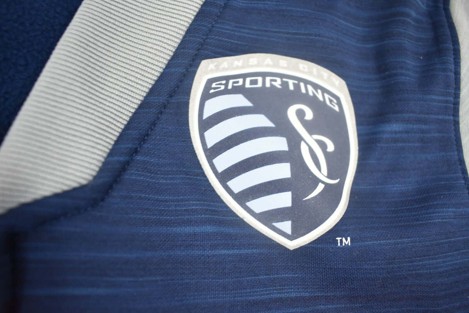 Sporting Kansas City Logo On Blue Grey Jersey Background