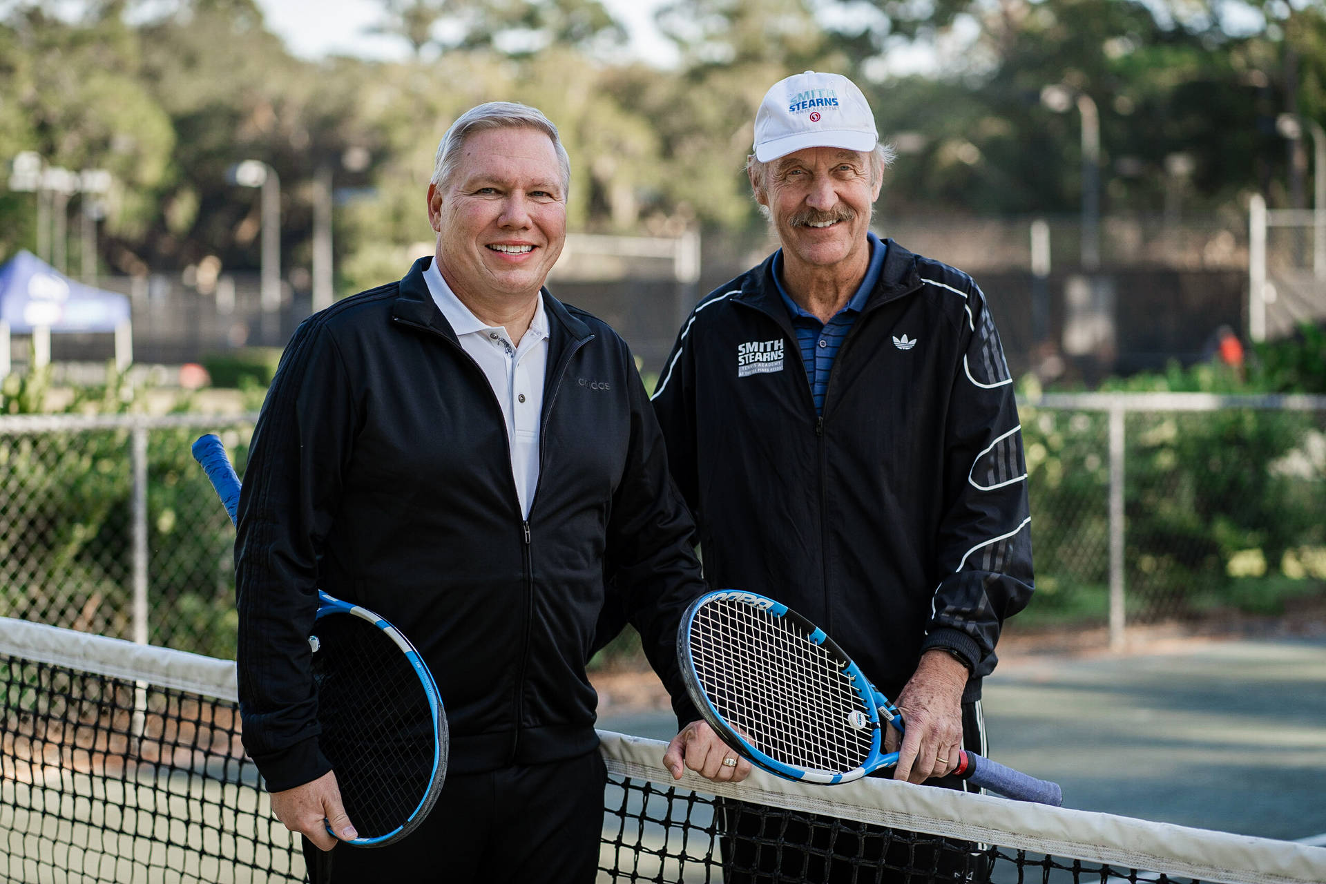 Stan Smith Wearing A Black Adidas Jacket Background