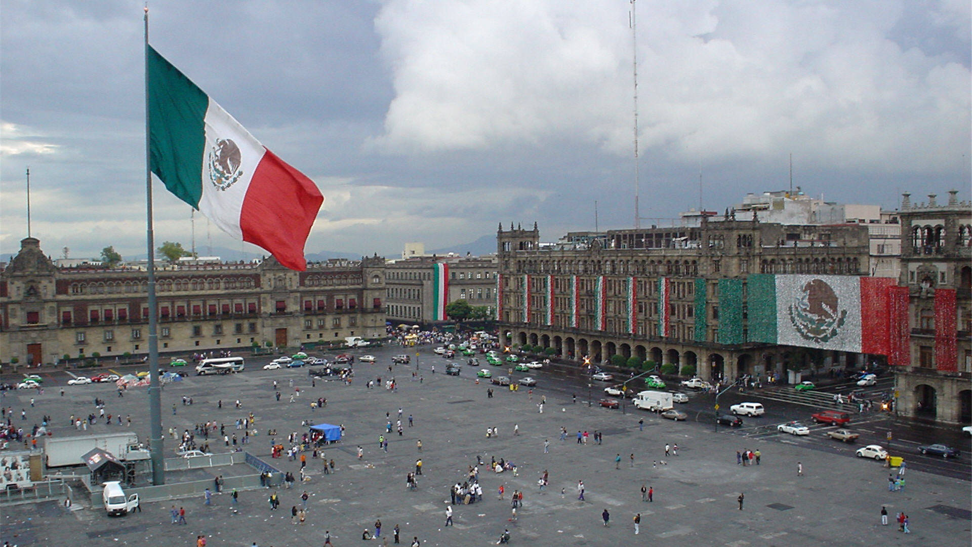 Standing Mexico Flag In The City Background