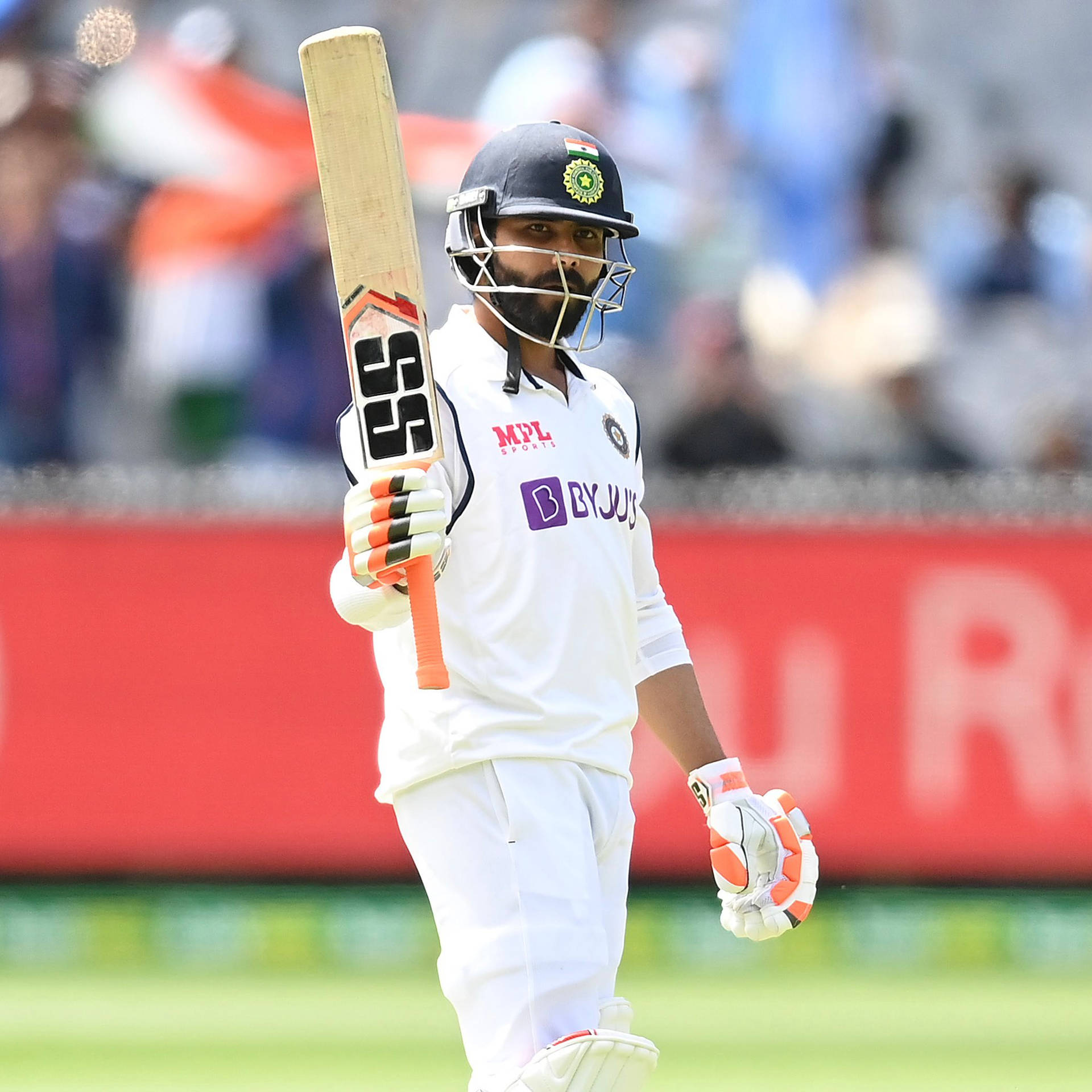 Standing Ravindra Jadeja Holding A Bat Background