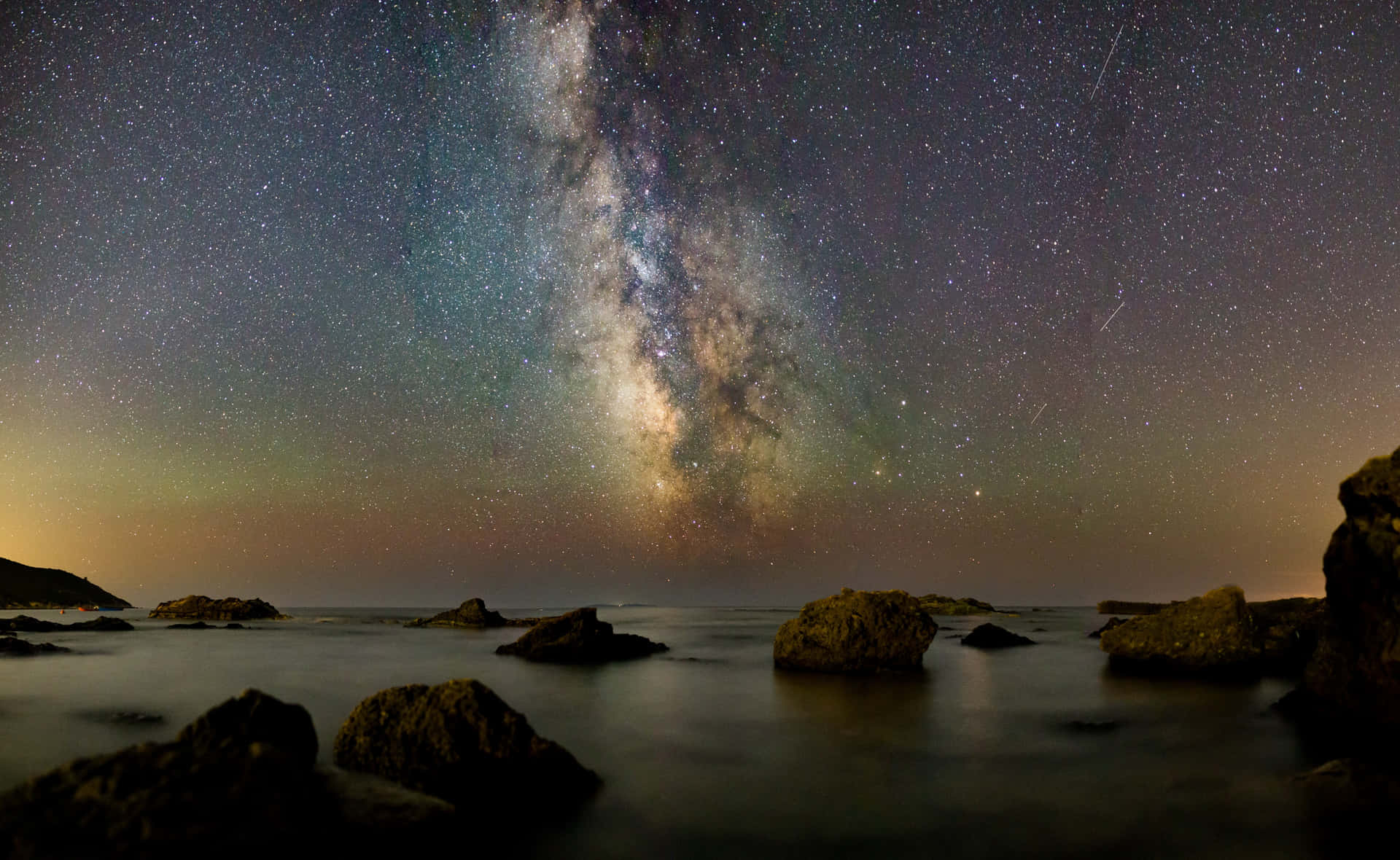 Star Sky Over Rocky Body Of Water Background