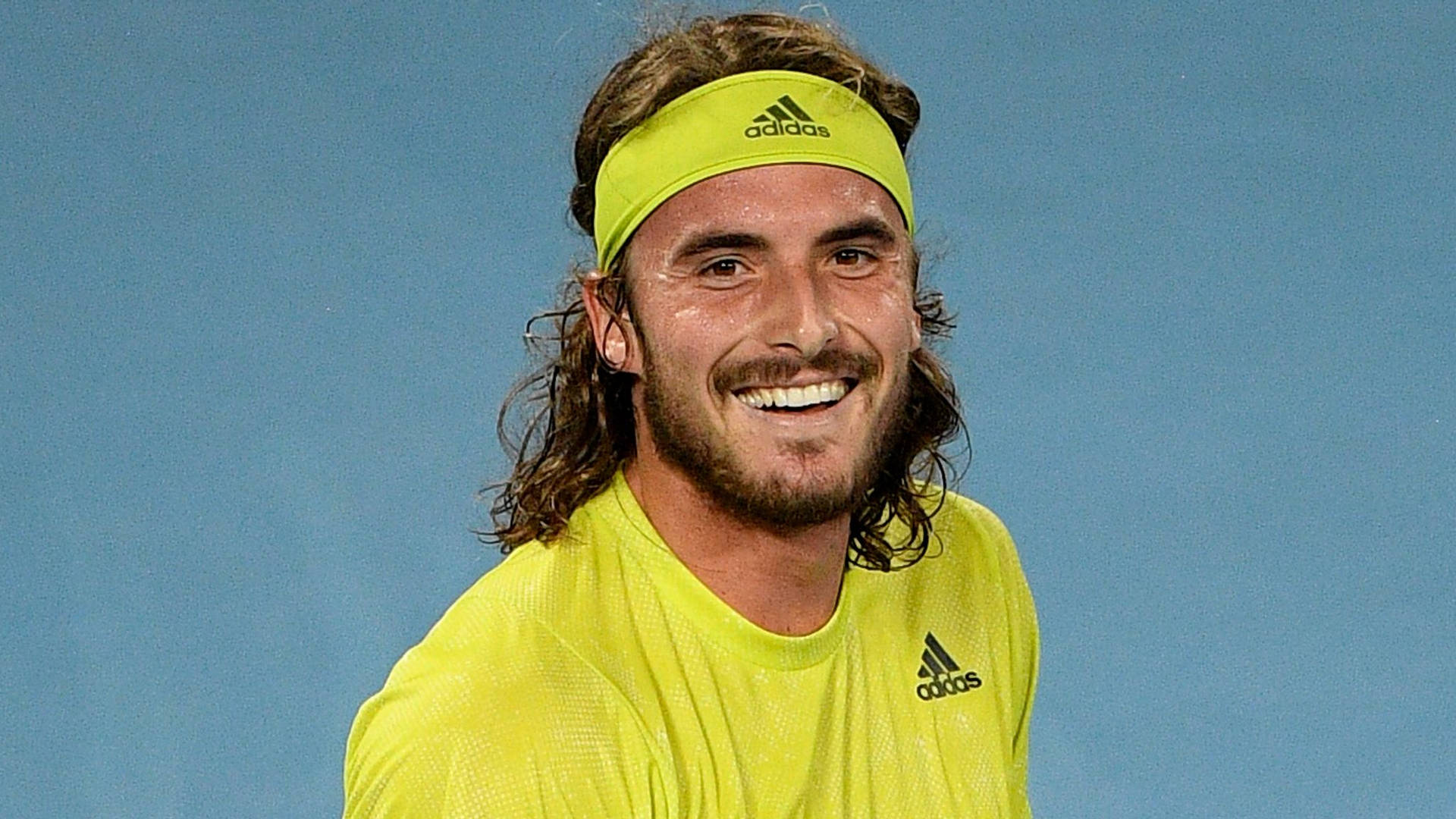 Stefanos Tsitsipas In Yellow Adidas Shirt Background