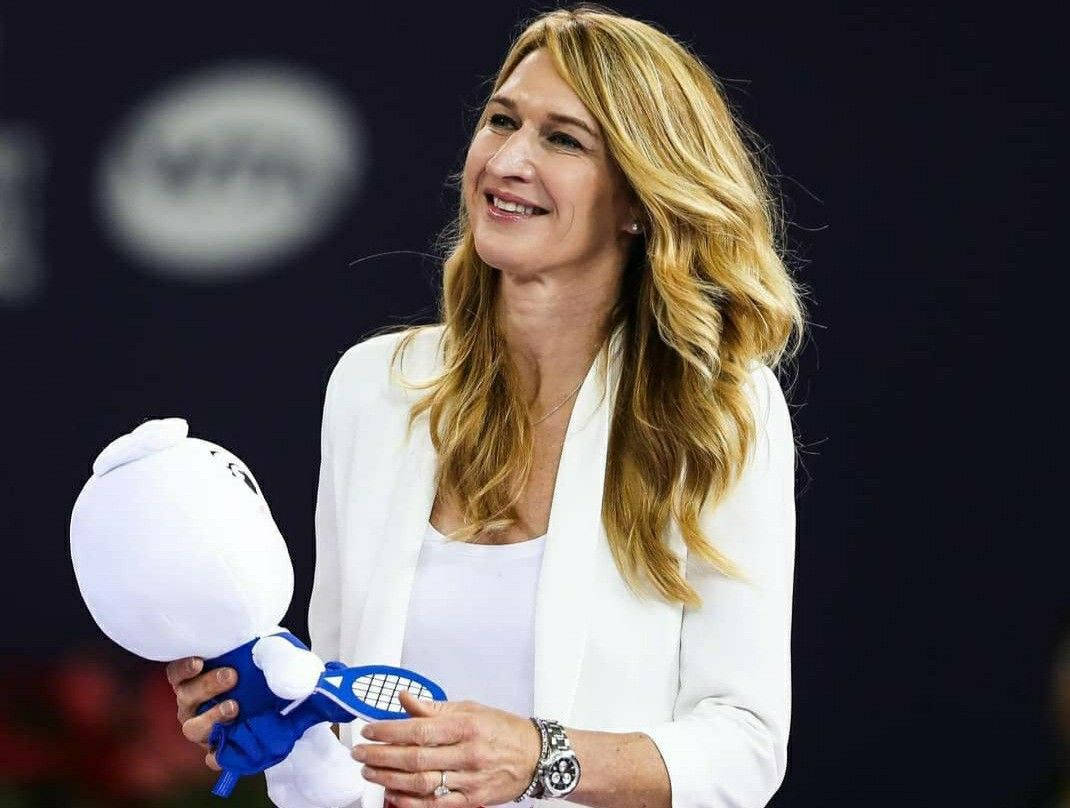 Steffi Graf Holding A Stuffed Toy Background