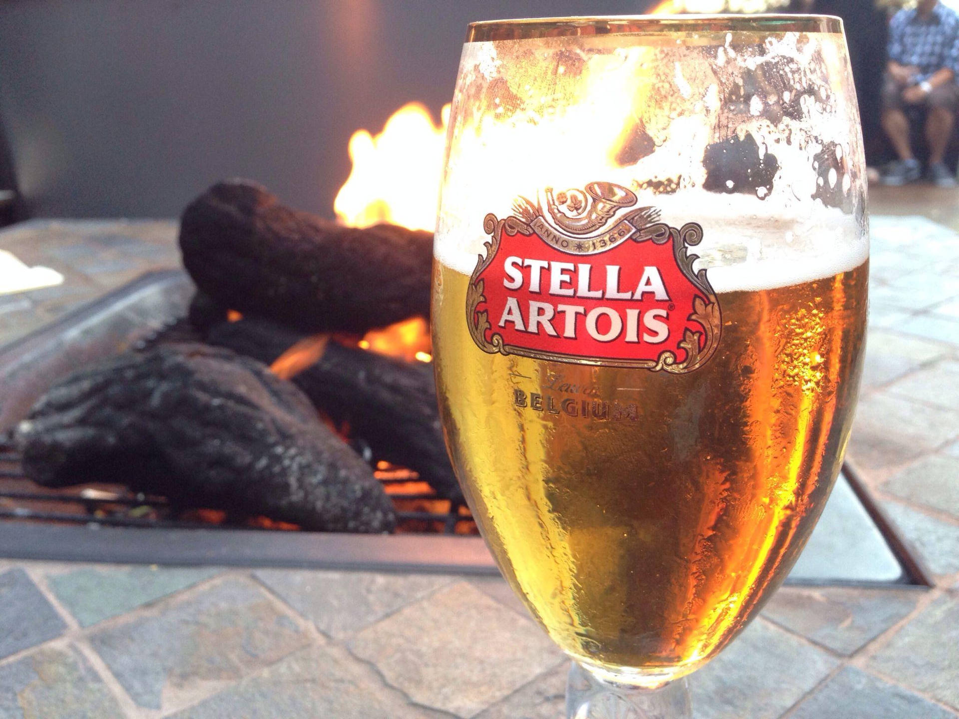 Stella Artois Beer By The Fireplace Background