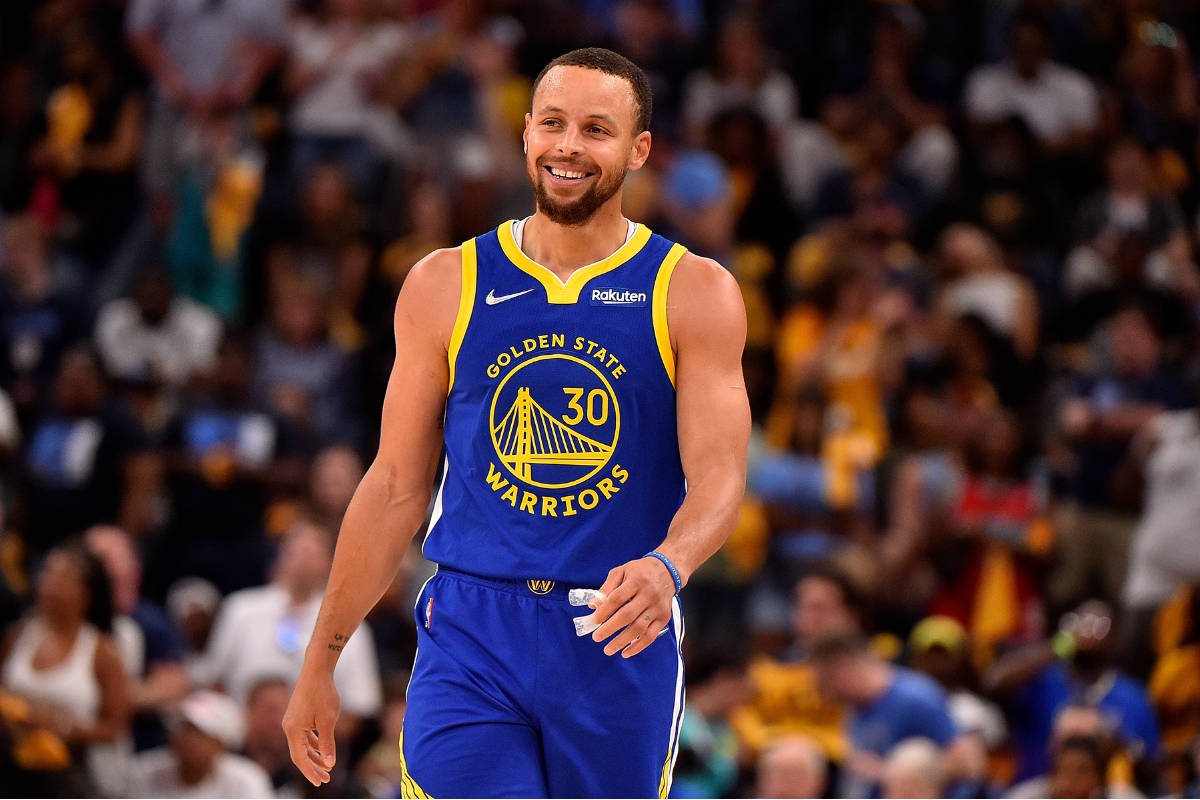 Steph Curry Smiling Against Blurry Crowd Background