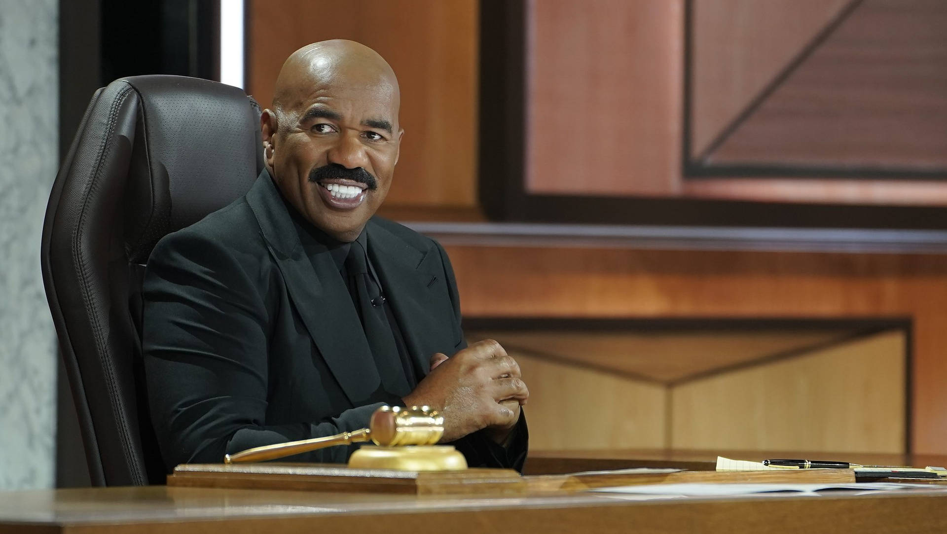 Steve Harvey Portraying Authority In A Classy Black Suit Background
