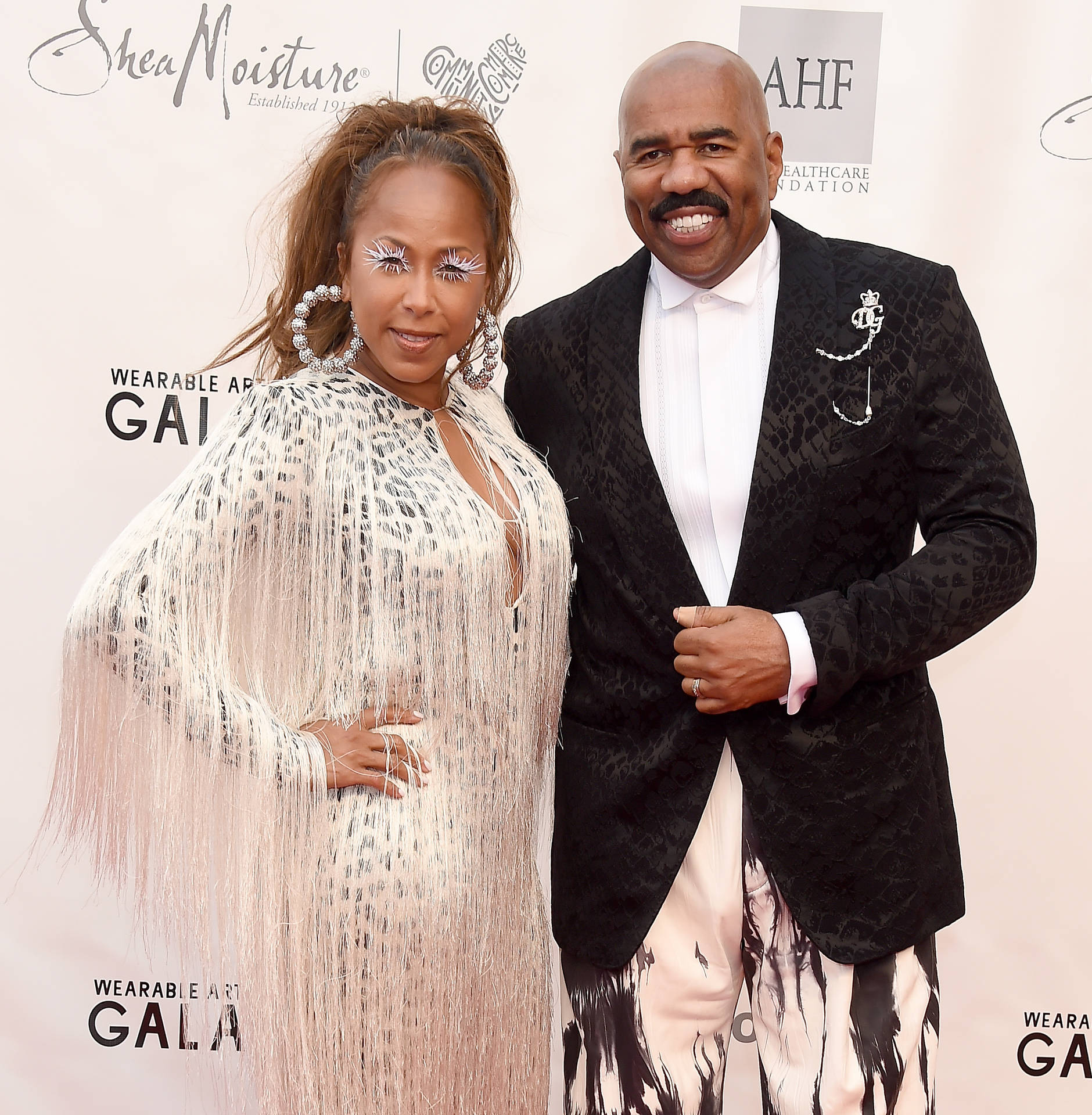 Steve Harvey Posing With His Wife Background
