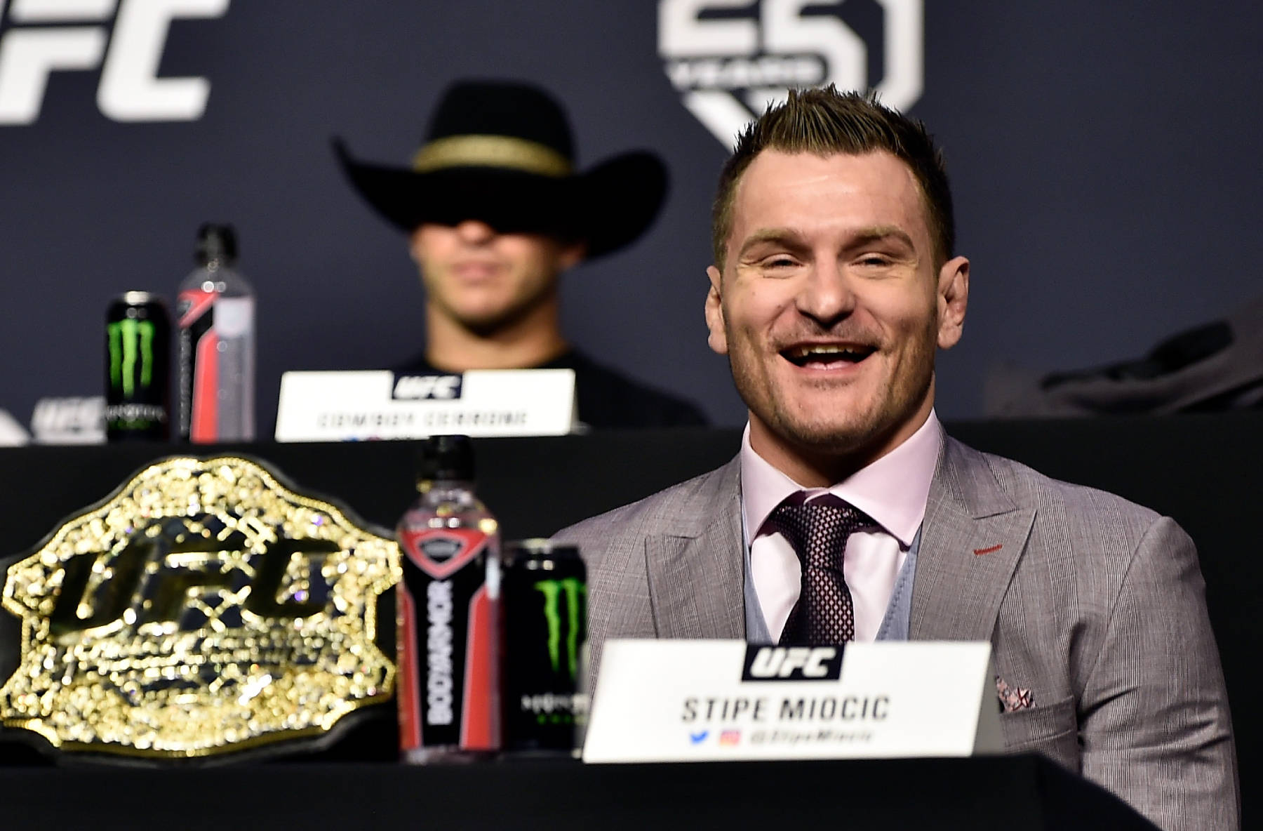 Stipe Miocic Smiling At Conference Background