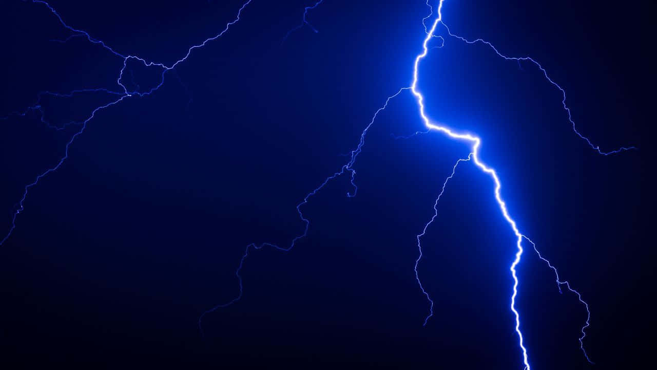 Striking Blue Lightning Against A Grey Sky