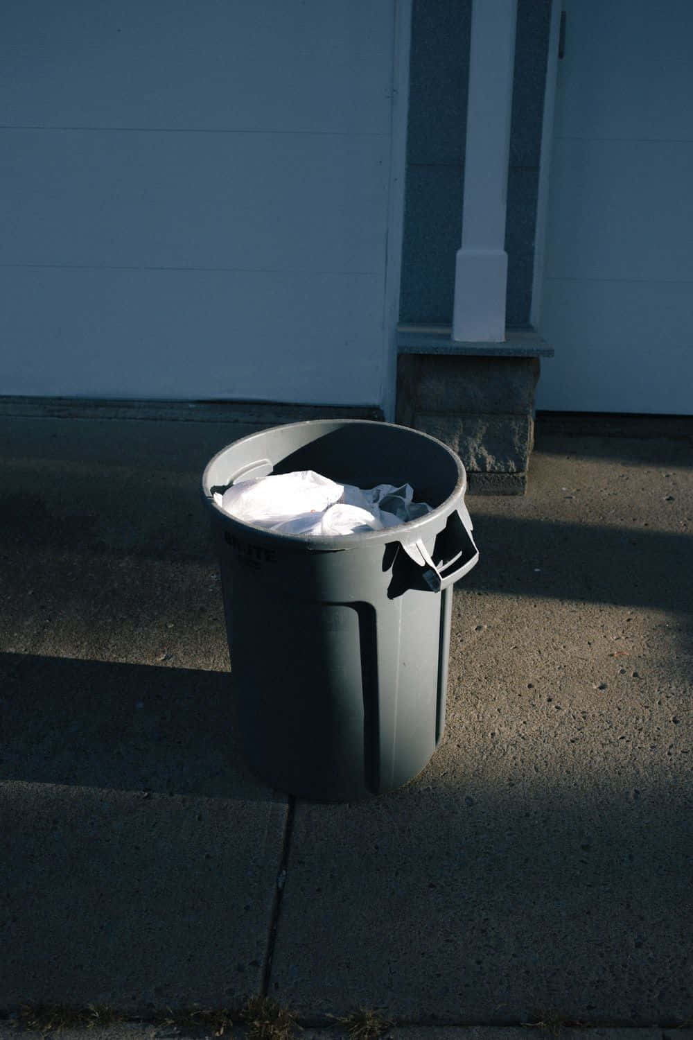 Striking Minimalistic Display Of A Black Plastic Trash Can Background