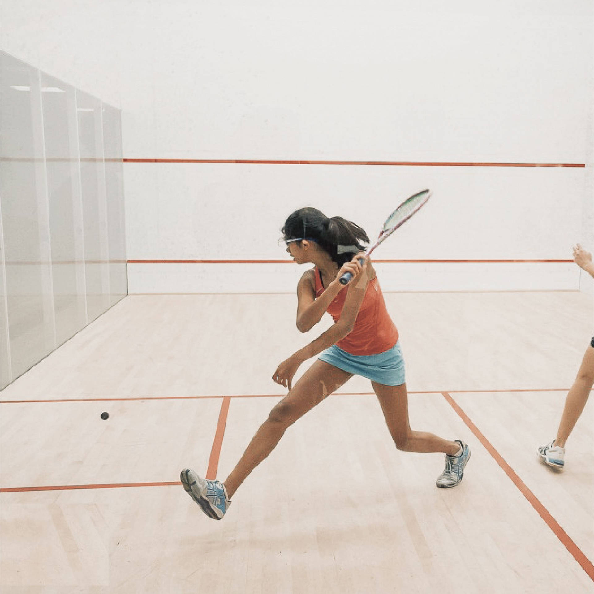 Strong Woman In Orange Playing Racquetball Background